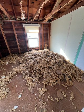 A man is working on a ventilation system in a building.
