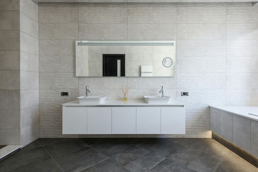 Salle de bains moderne avec double vasque, grand miroir et murs carrelés blancs