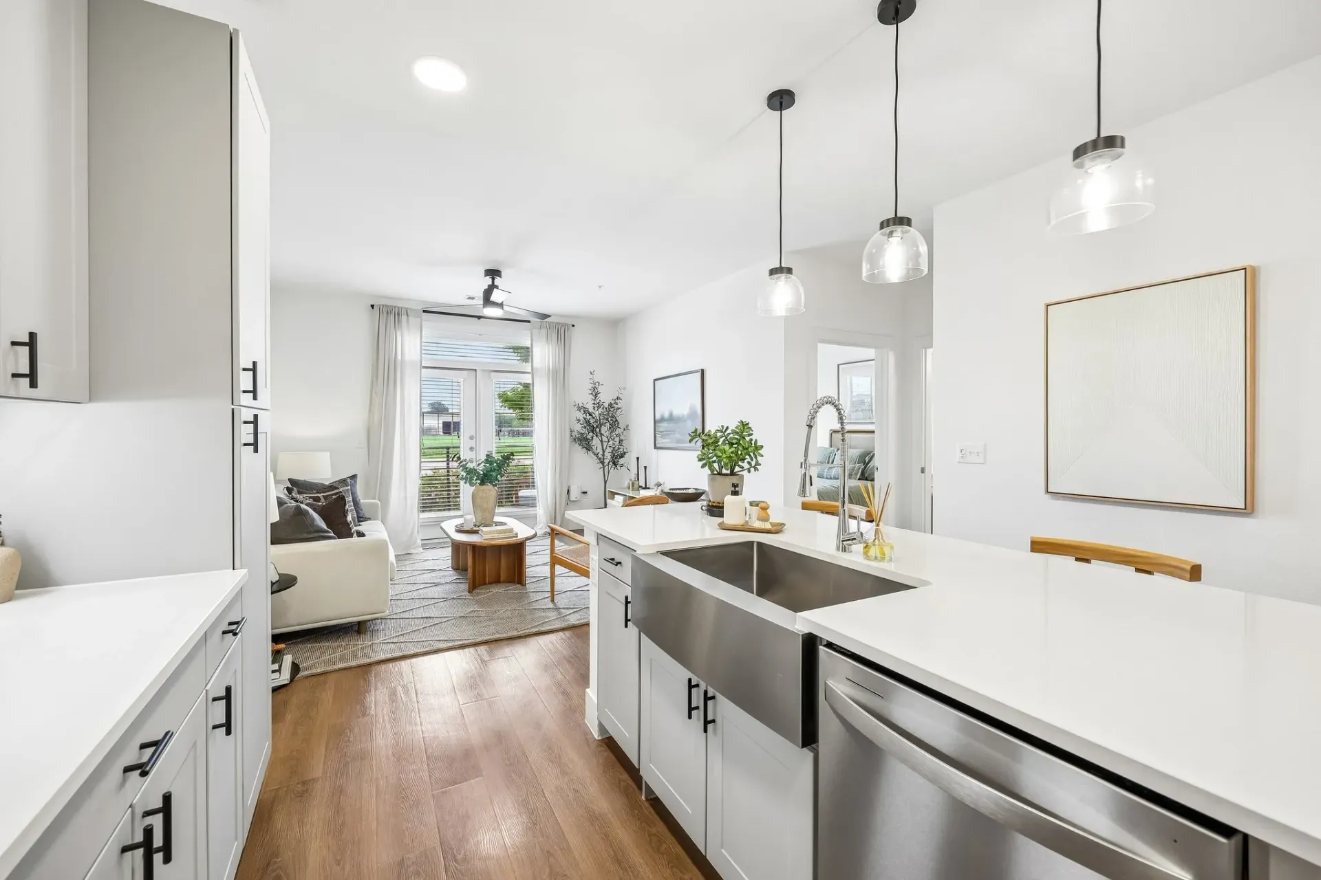 Modern kitchen with island and living room view at The Grayson.
