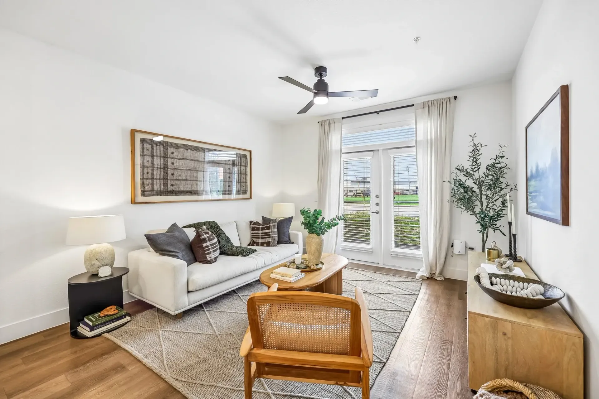 Living room with a white couch, coffee table, and armchair at The Grayson.