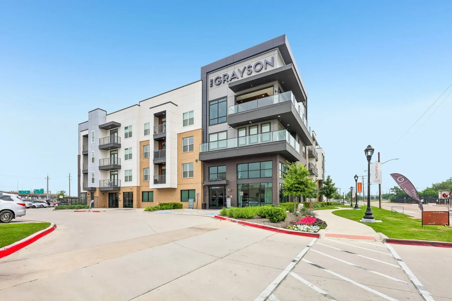 Exterior view of the Grayson apartment building with modern architecture and balconies in Fort Worth, TX.