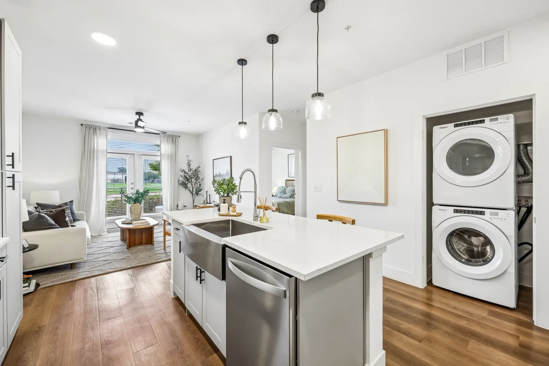 Modern kitchen with island, stainless steel appliances, and open living area at The Grayson.