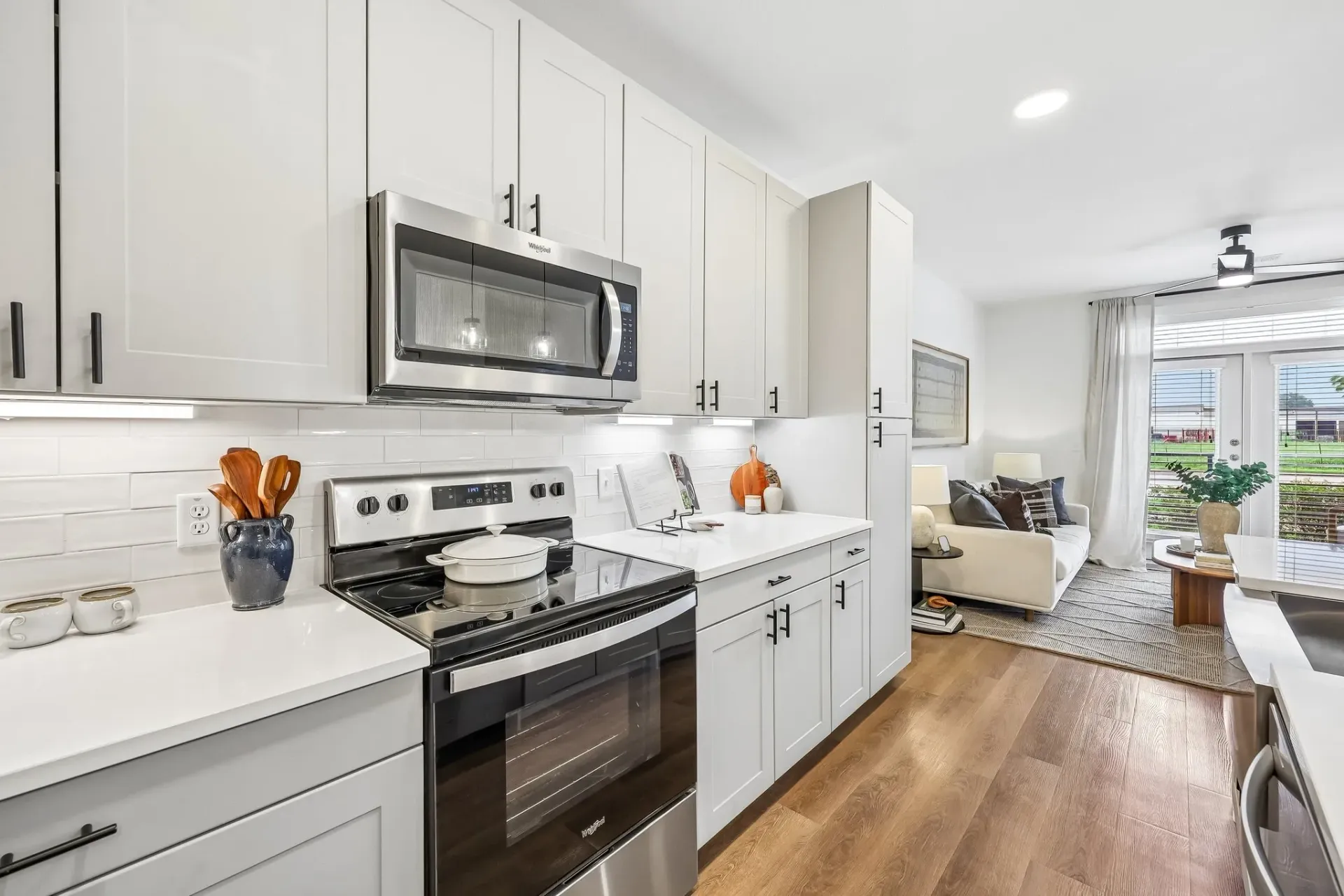 Modern kitchen with stainless steel appliances and white cabinetry at The Grayson.