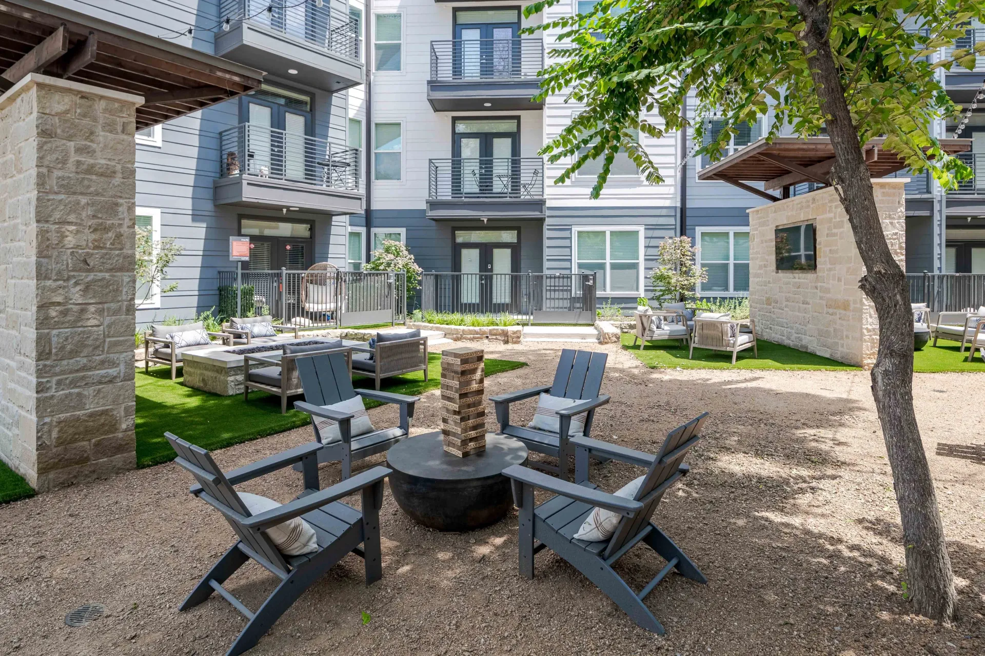 Outdoor courtyard seating area with fire pit and giant Jenga game at The Grayson in Fort Worth, TX.