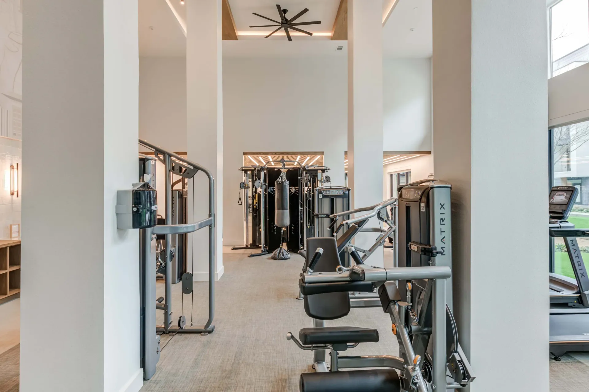 Gym with various weight machines, a punching bag, and treadmills at The Grayson apartments in Fort Worth, TX..