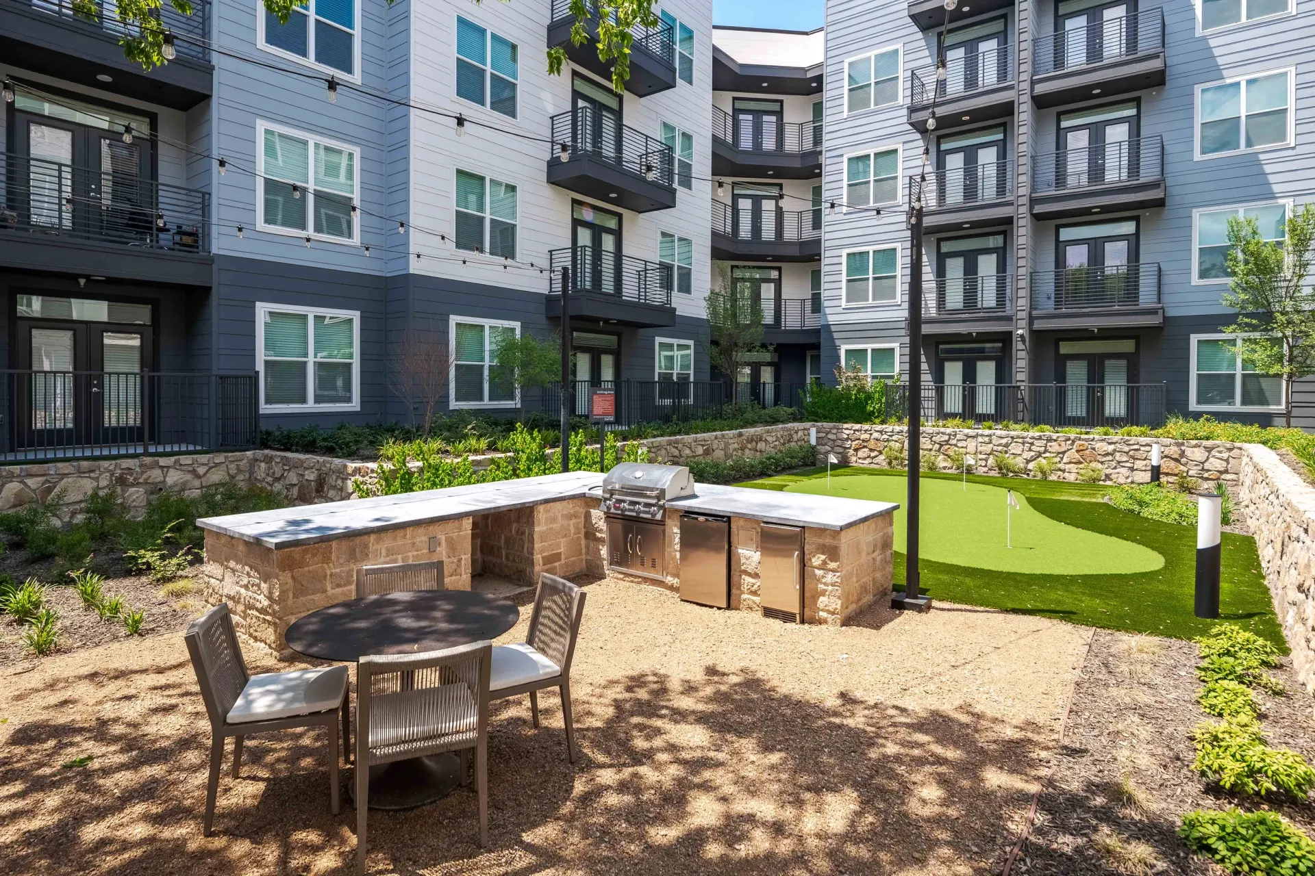 Outdoor grilling station and putting green at a multifamily property at The Grayson in Fort Worth, TX.