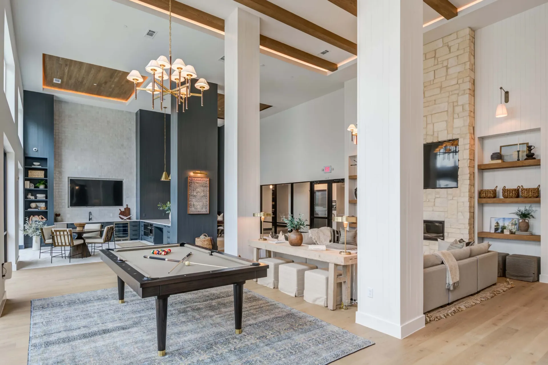 Spacious community lounge with a pool table, seating area, and kitchen at The Grayson apartments in Fort Worth, TX..