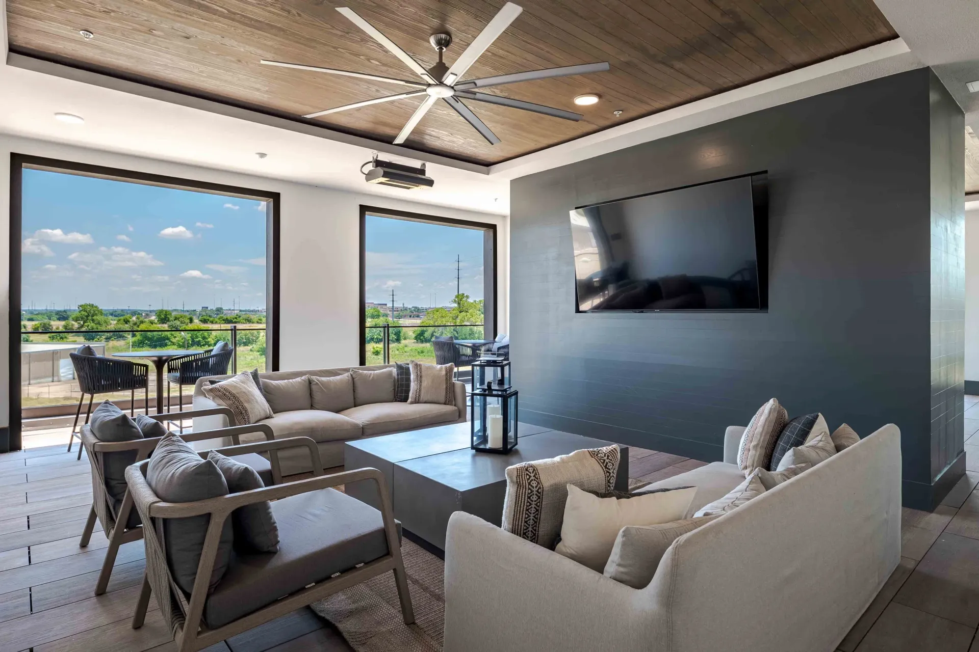 Modern lounge area with comfortable seating, coffee table, and large windows overlooking a scenic view at The Grayson in Fort Worth, TX.