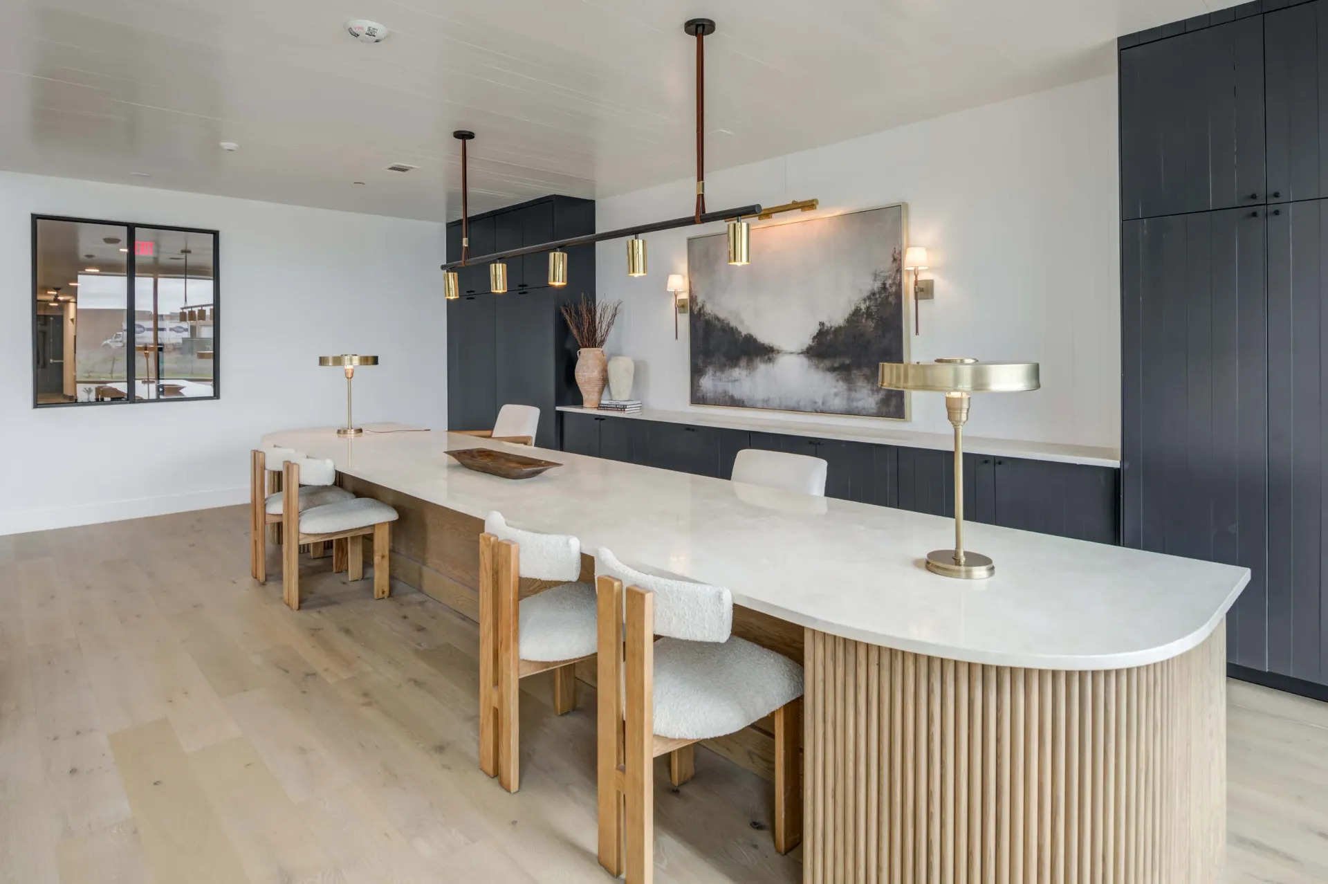 Modern communal dining table with chairs in a well-lit room at The Grayson apartments in Fort Worth, TX..