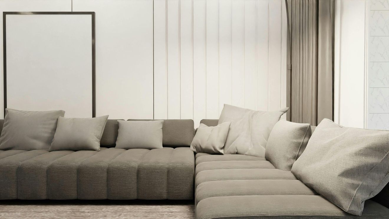 A neutral-toned sectional sofa with several textured cushions in a bright, modern living room.