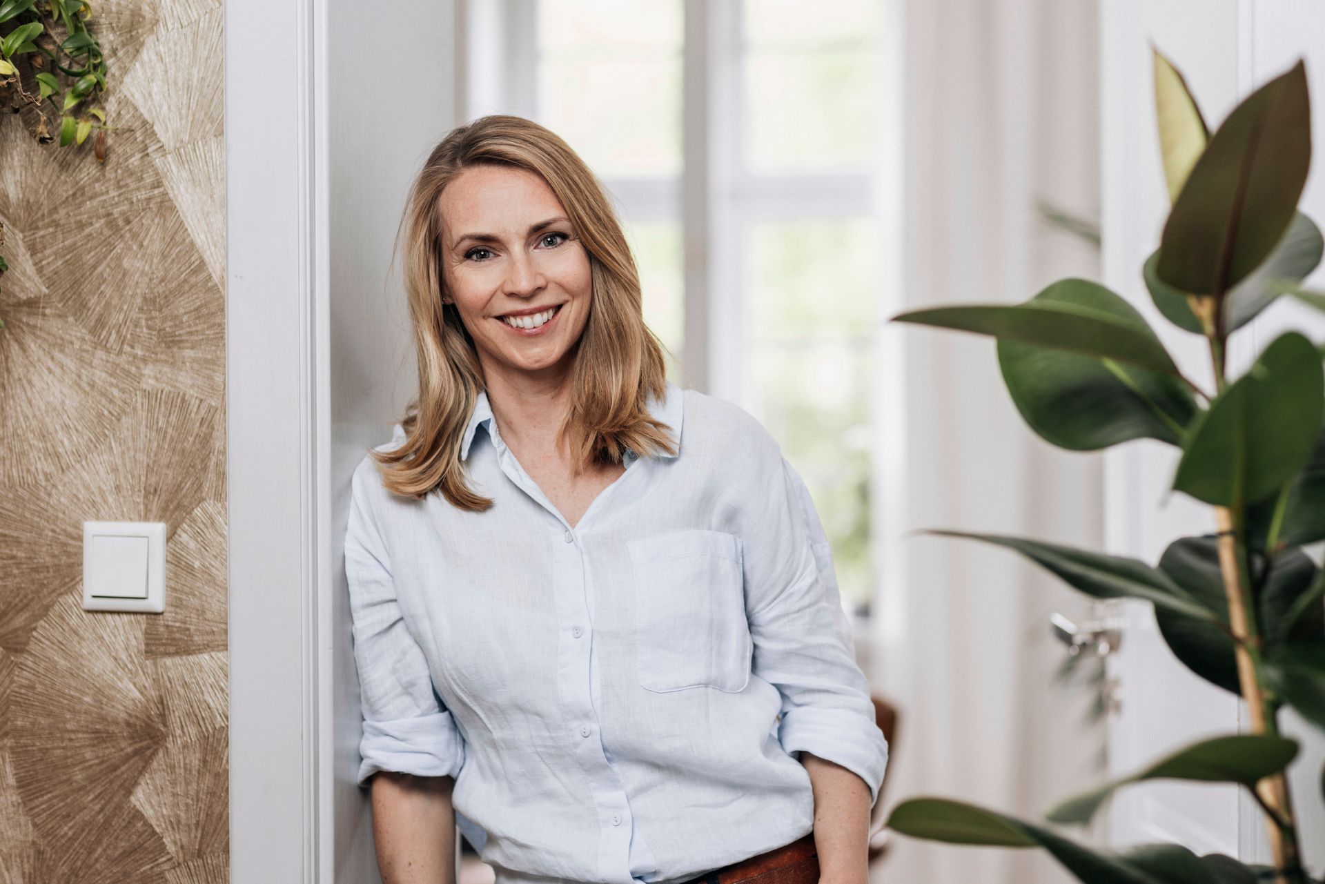 Amelie Rammoser lehtn am Türrahmen und lächelt in die Kamera