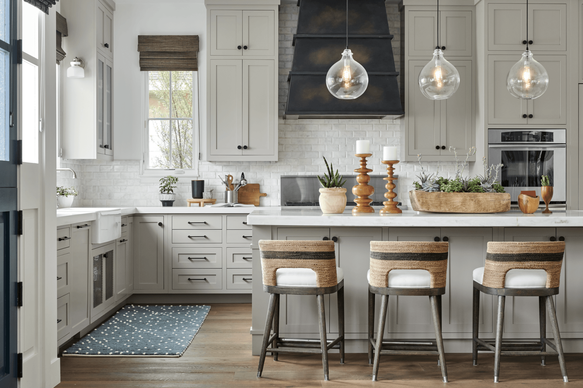A kitchen with white cabinets , a stove , a sink , and a large island.