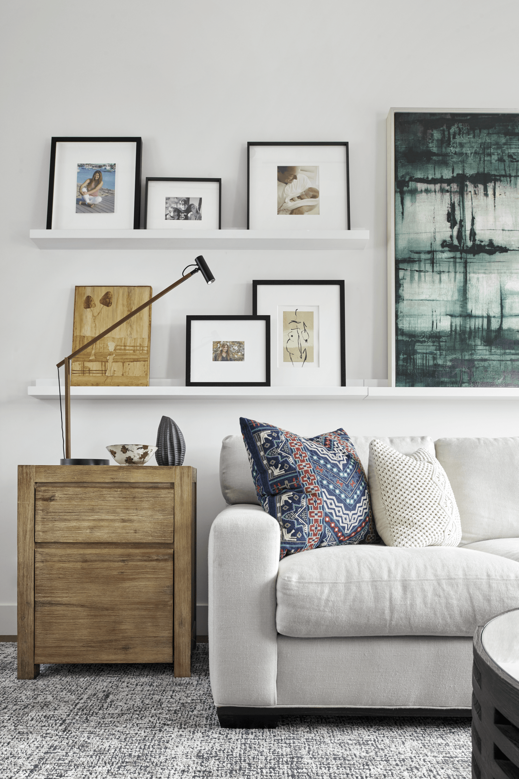 A living room with a white couch and a wooden nightstand