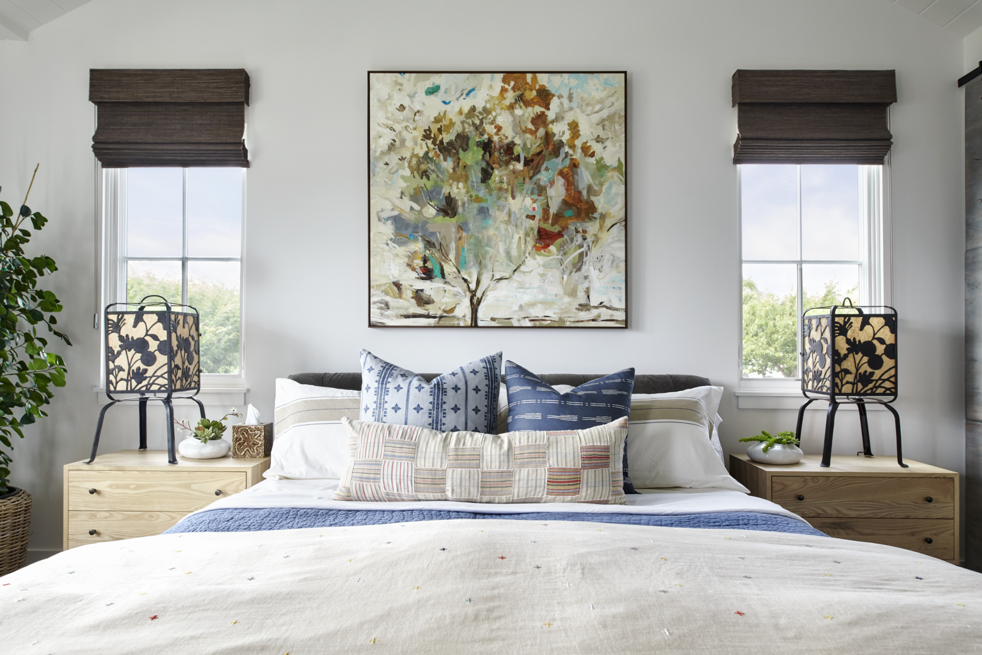 There is a painting on the wall above the bed in the bedroom.