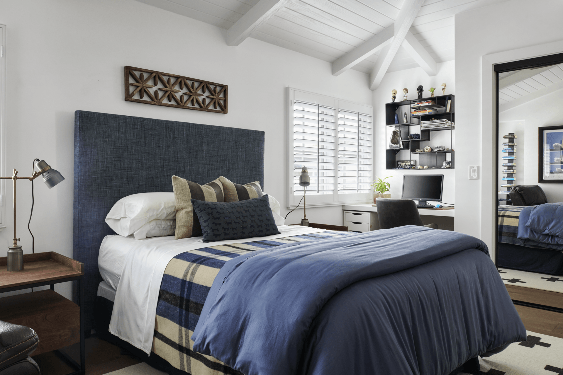 A bedroom with a blue bed and a blue headboard.
