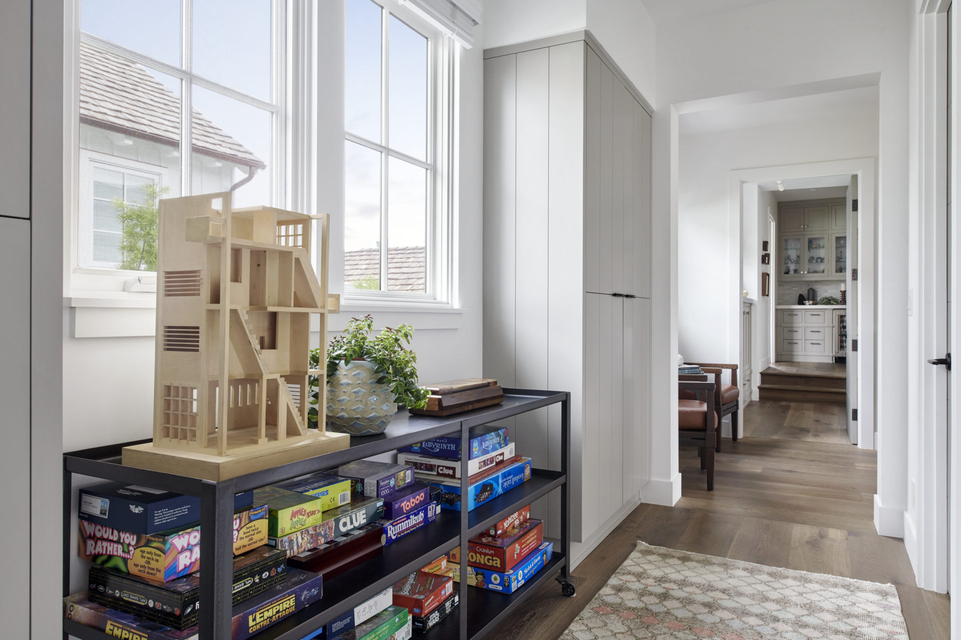 A room with a table full of board games and a doll house.