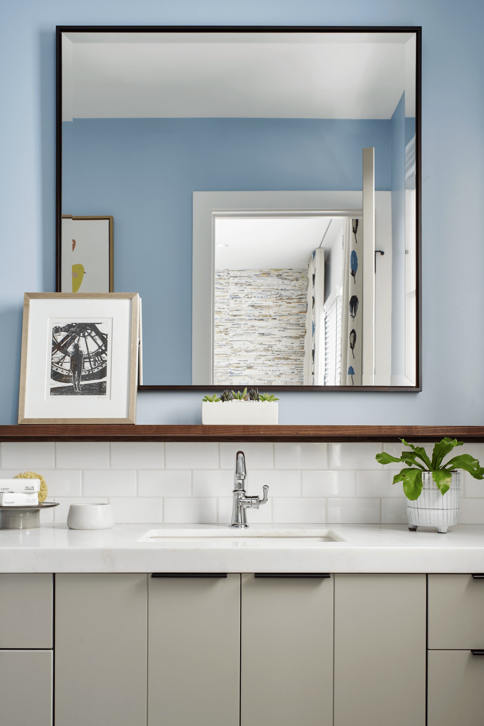 A bathroom with a sink and a large mirror