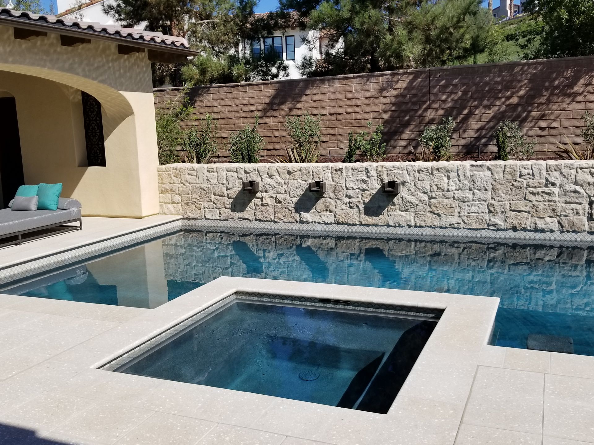 A large swimming pool with a hot tub in the middle