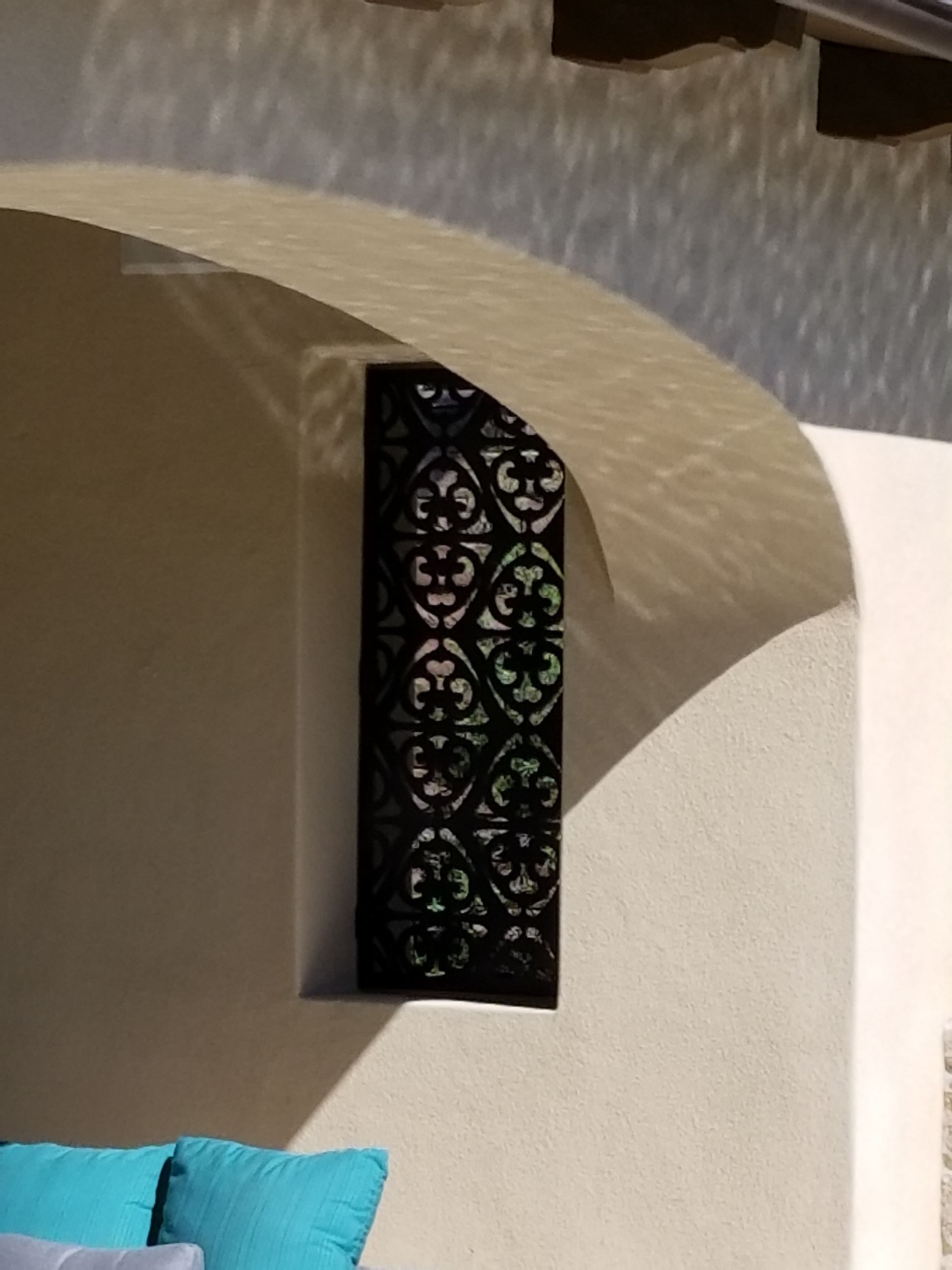 A couch with blue pillows sits under an archway