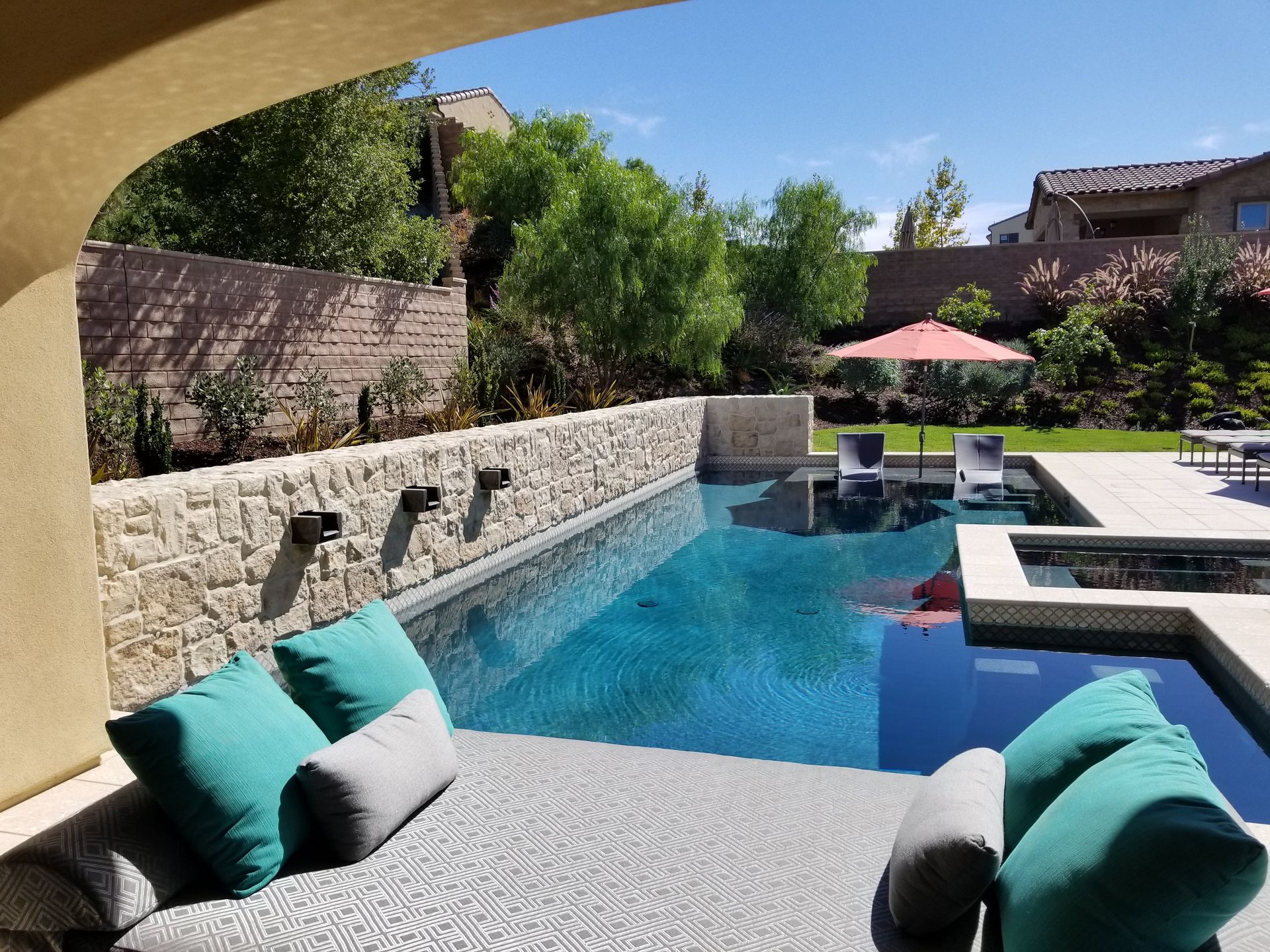 A large swimming pool is surrounded by chairs and umbrellas