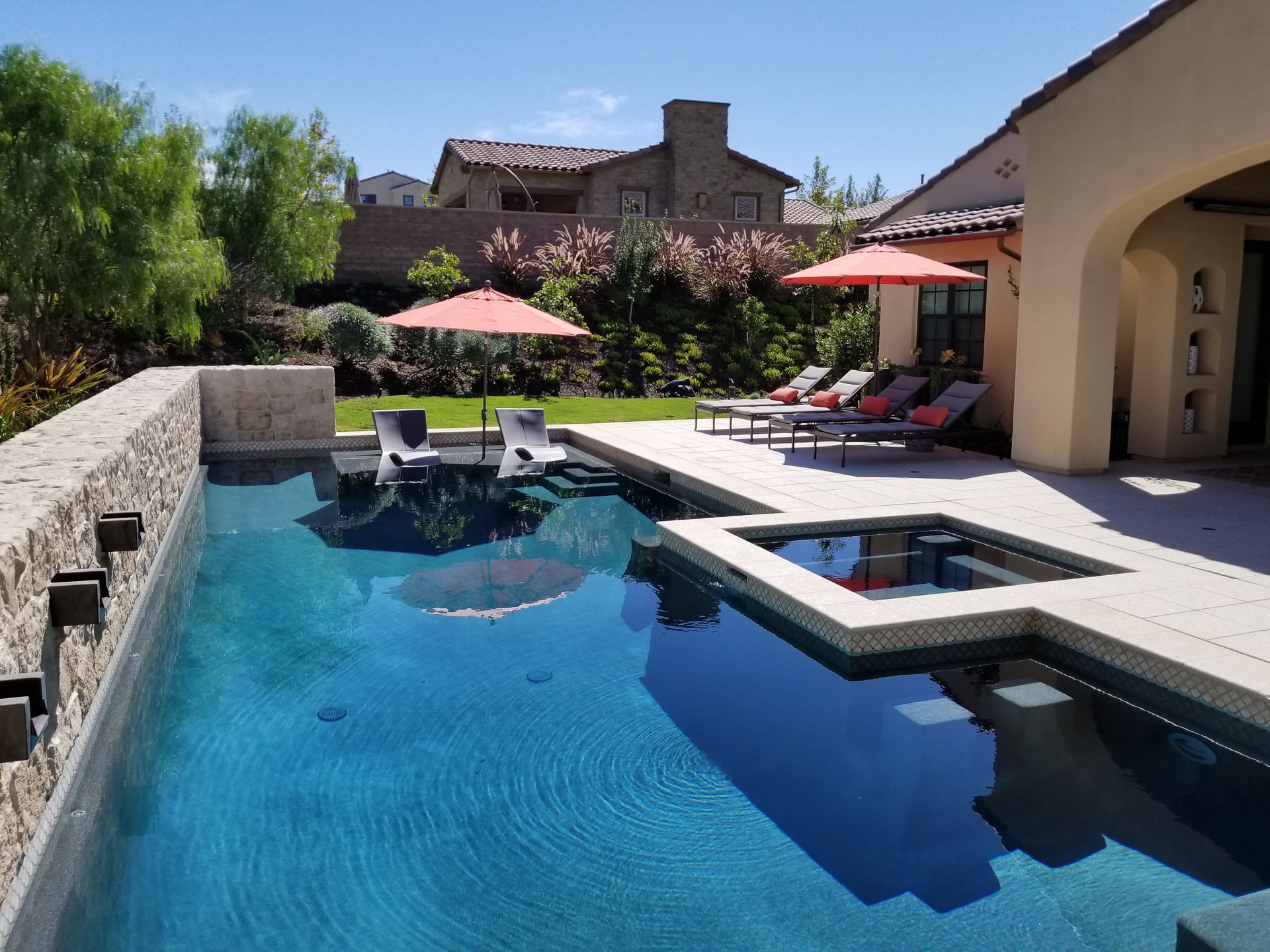 A large swimming pool surrounded by chairs and umbrellas