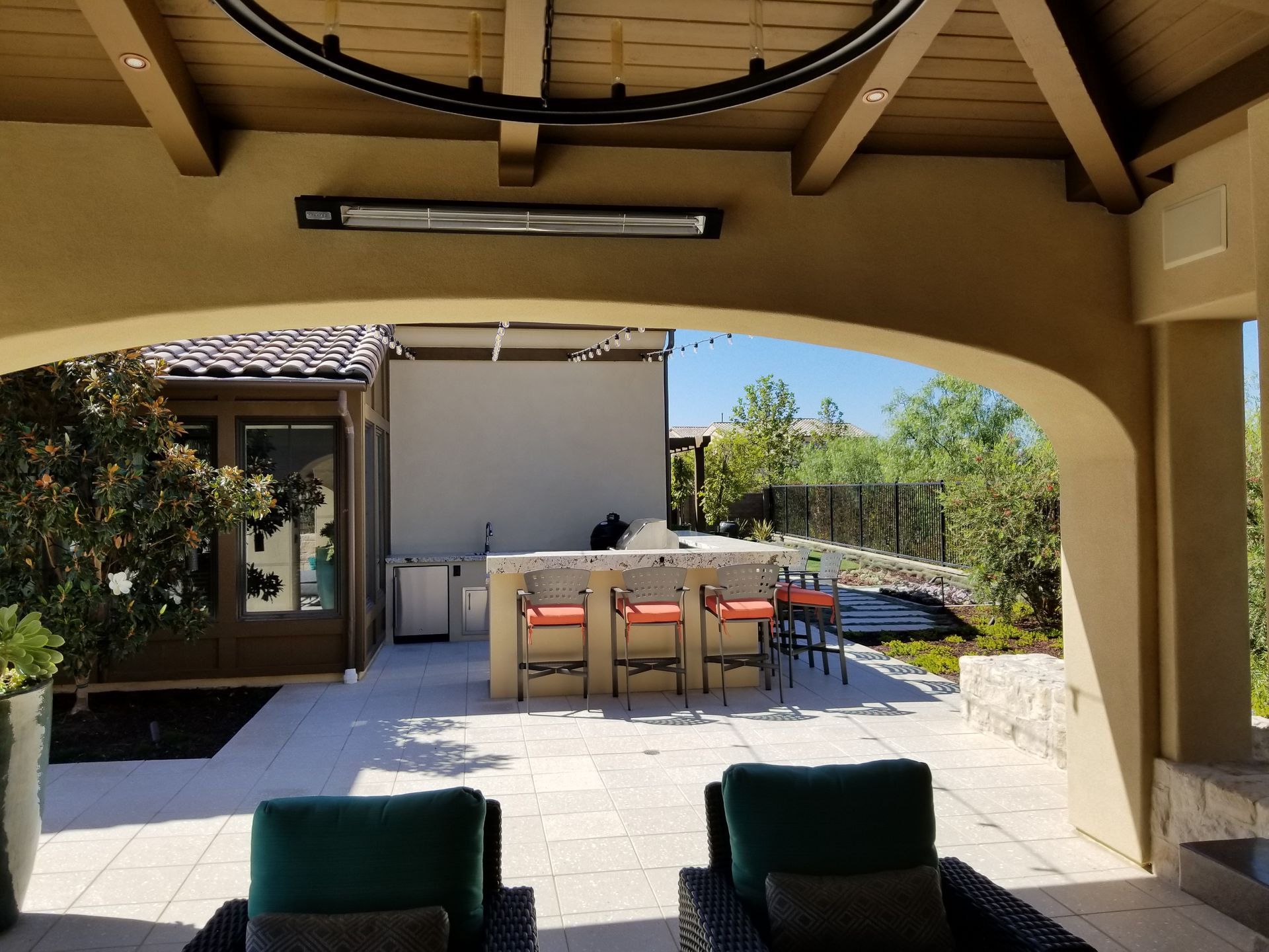 A patio with chairs and a heater on the ceiling
