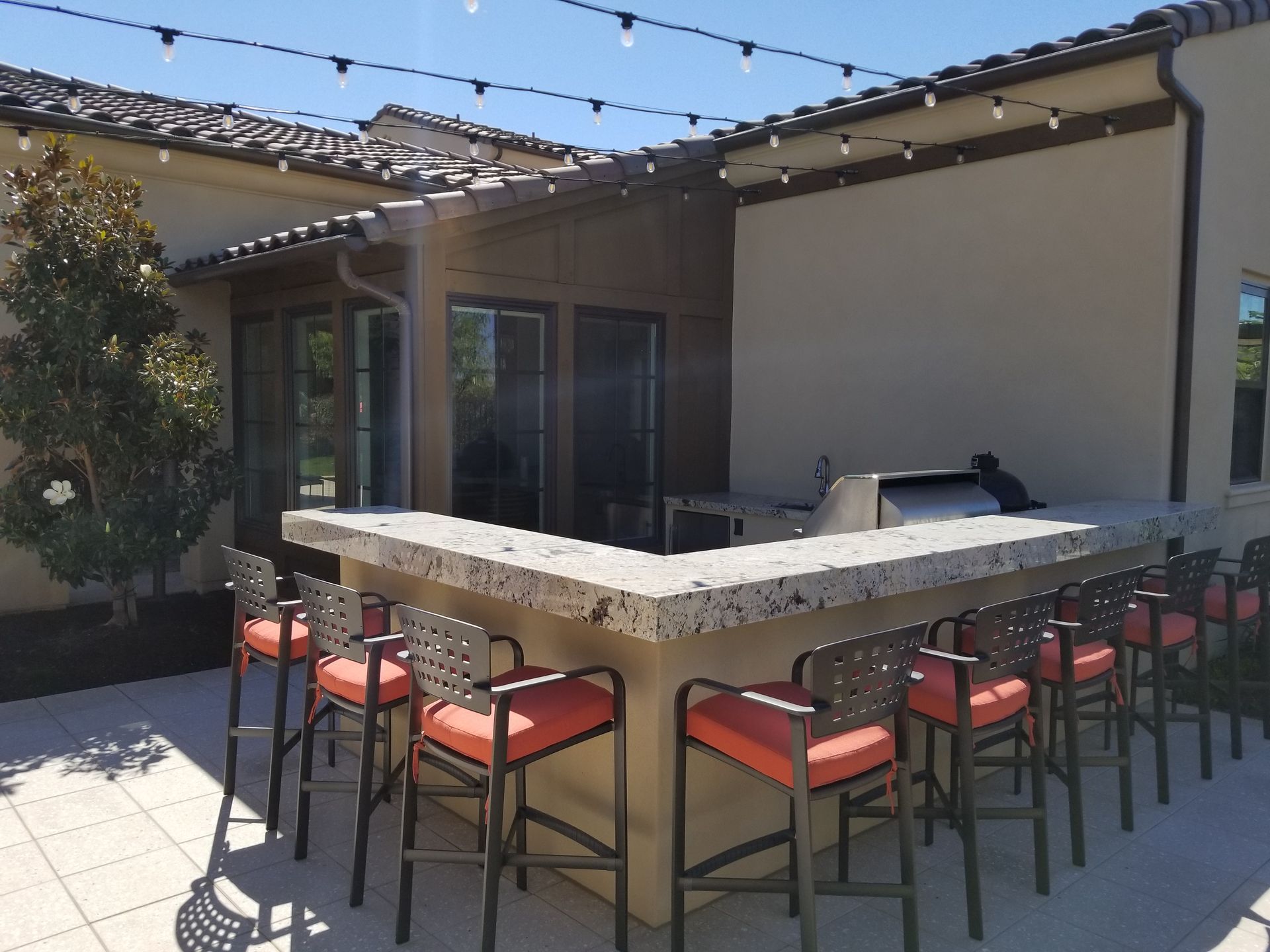 A patio with a bar and stools in front of a house