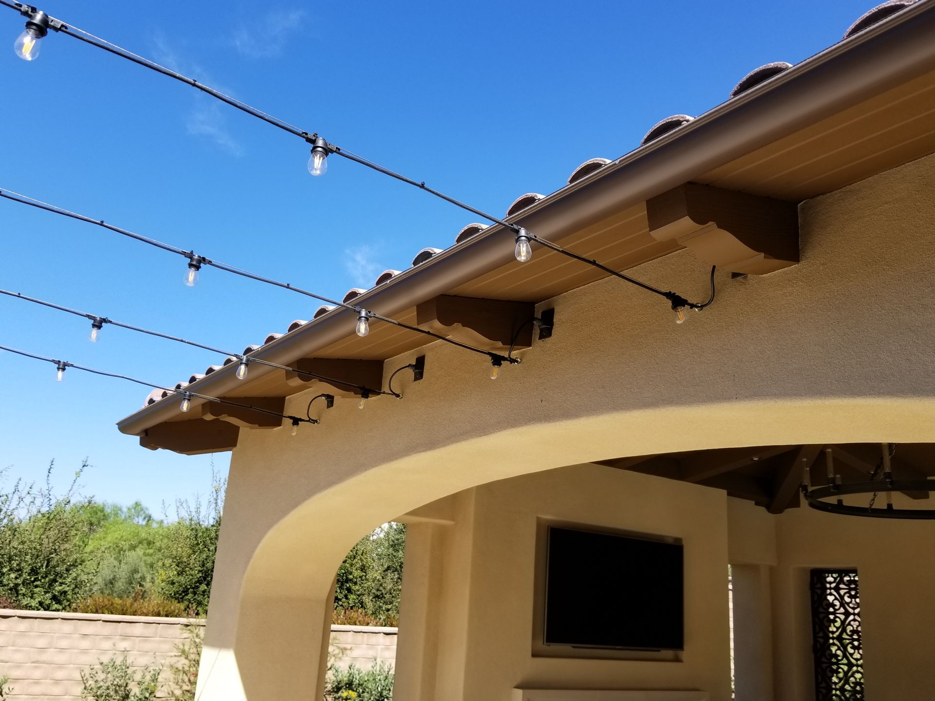 A roof with a tv on it and a string of lights hanging from it