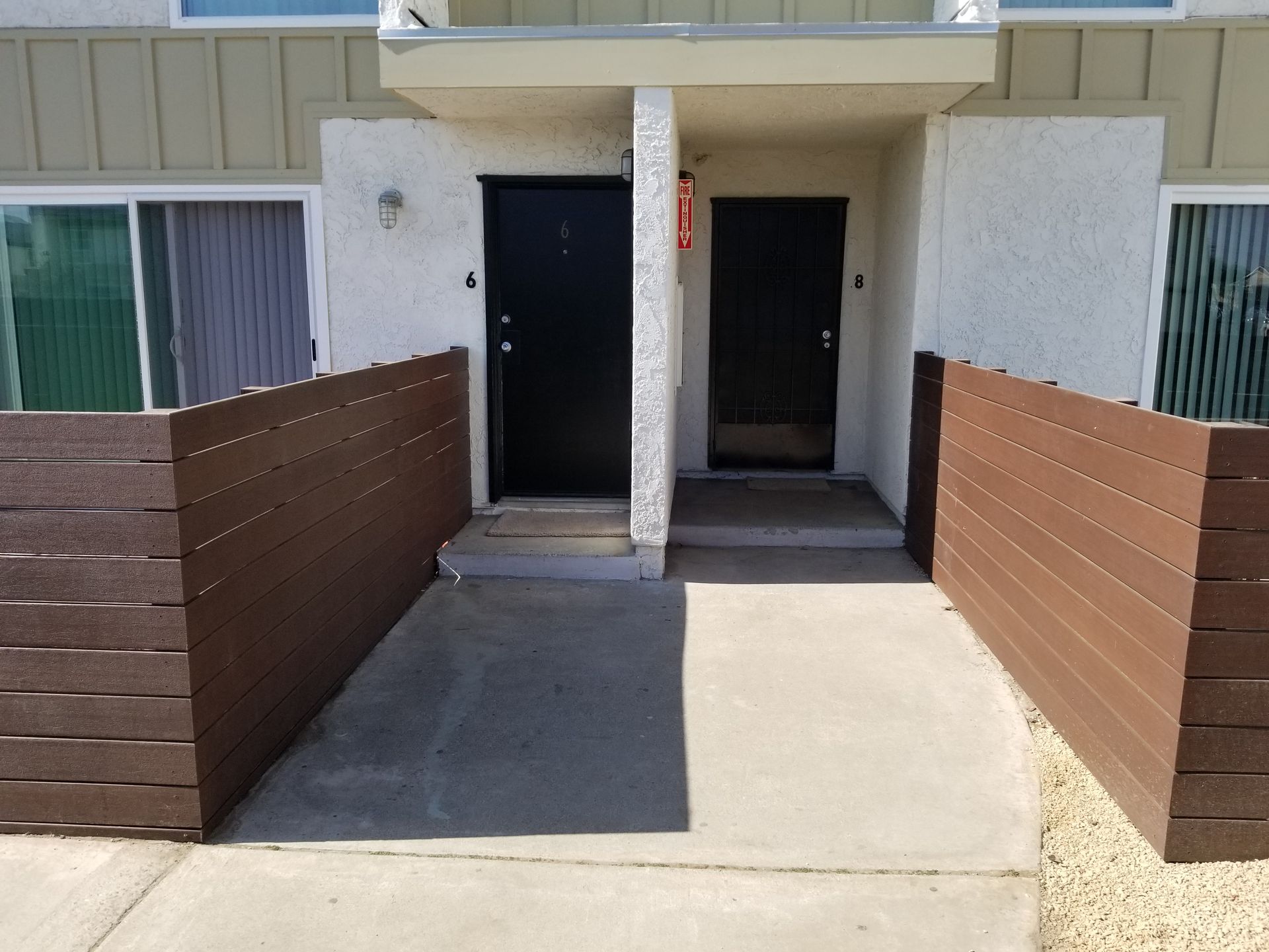 A building with two doors and a wooden fence