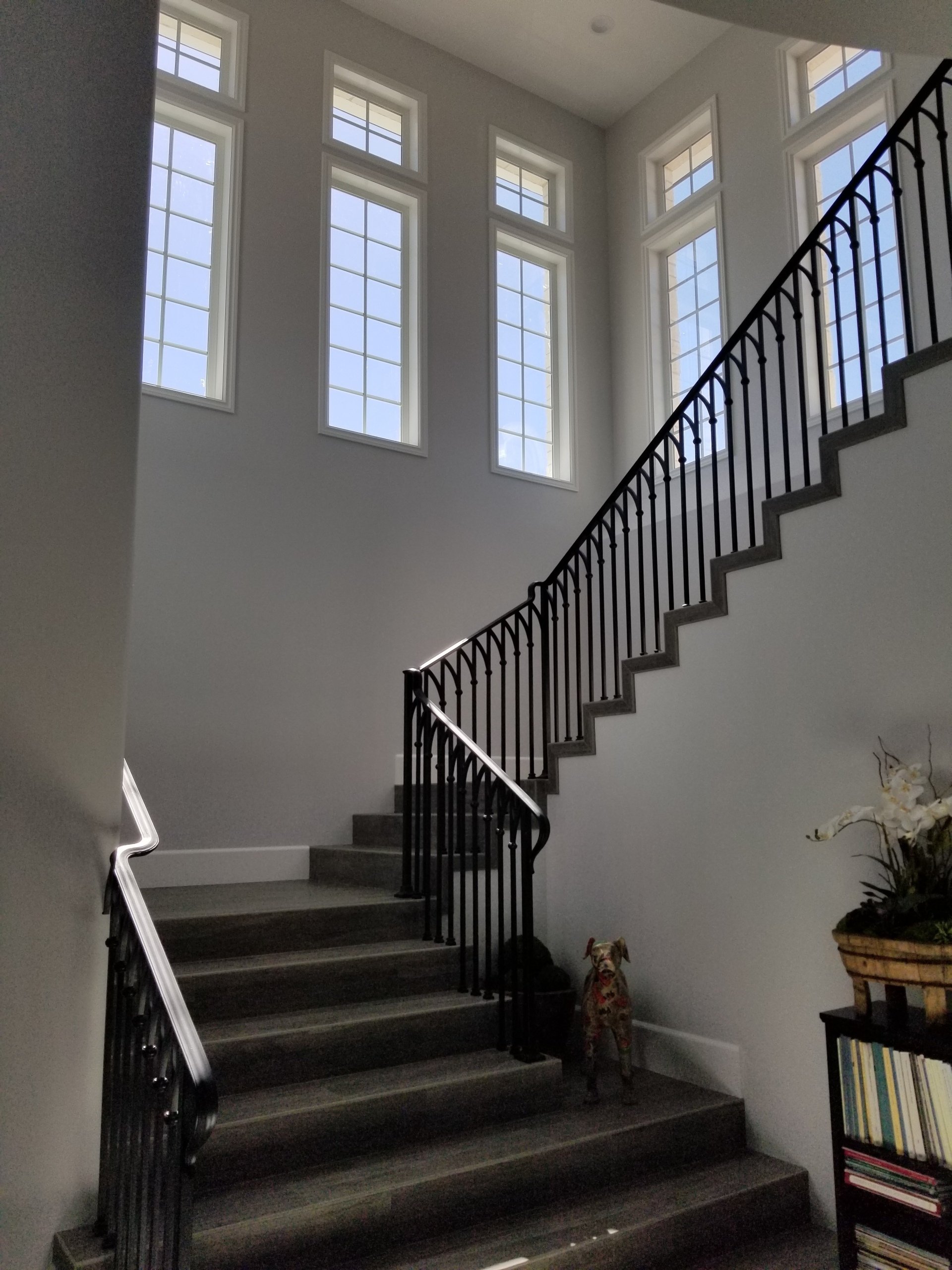 A staircase with a wrought iron railing and lots of windows