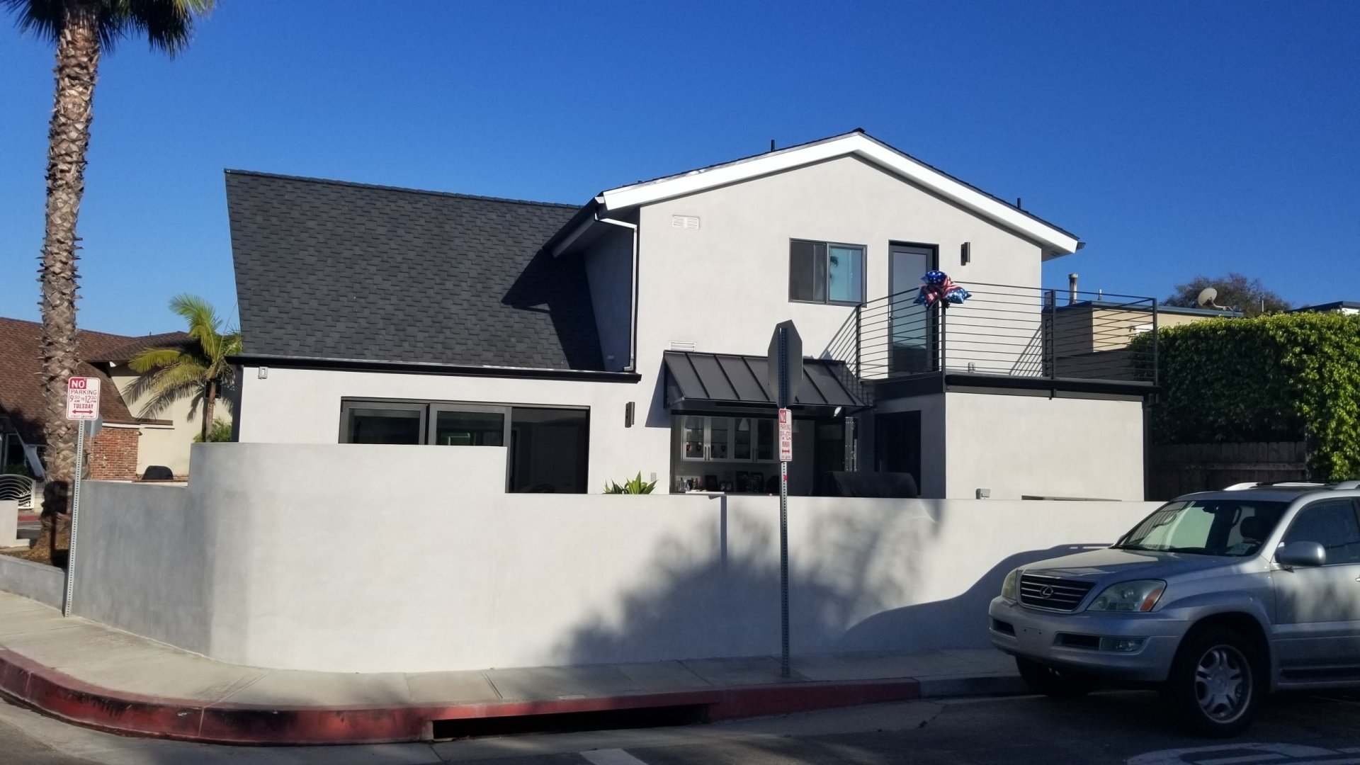 A white house with a car parked in front of it