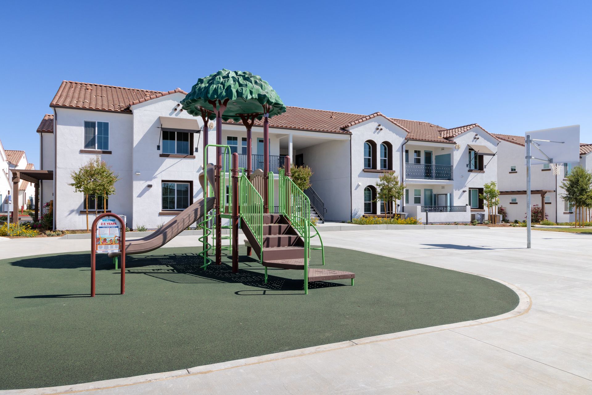 A playground with a slide and stairs in front of a building