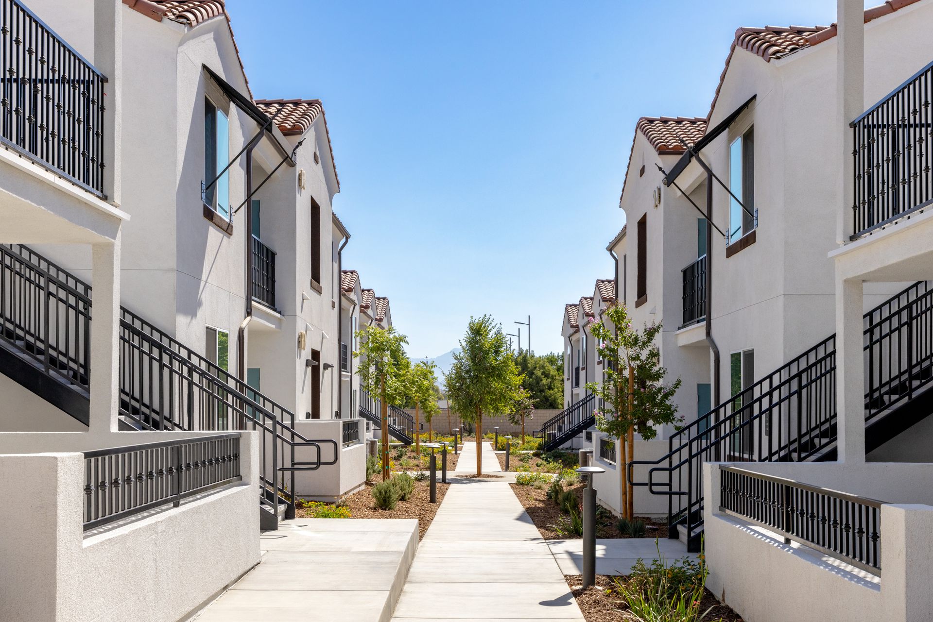 A row of white buildings with stairs leading up to them.