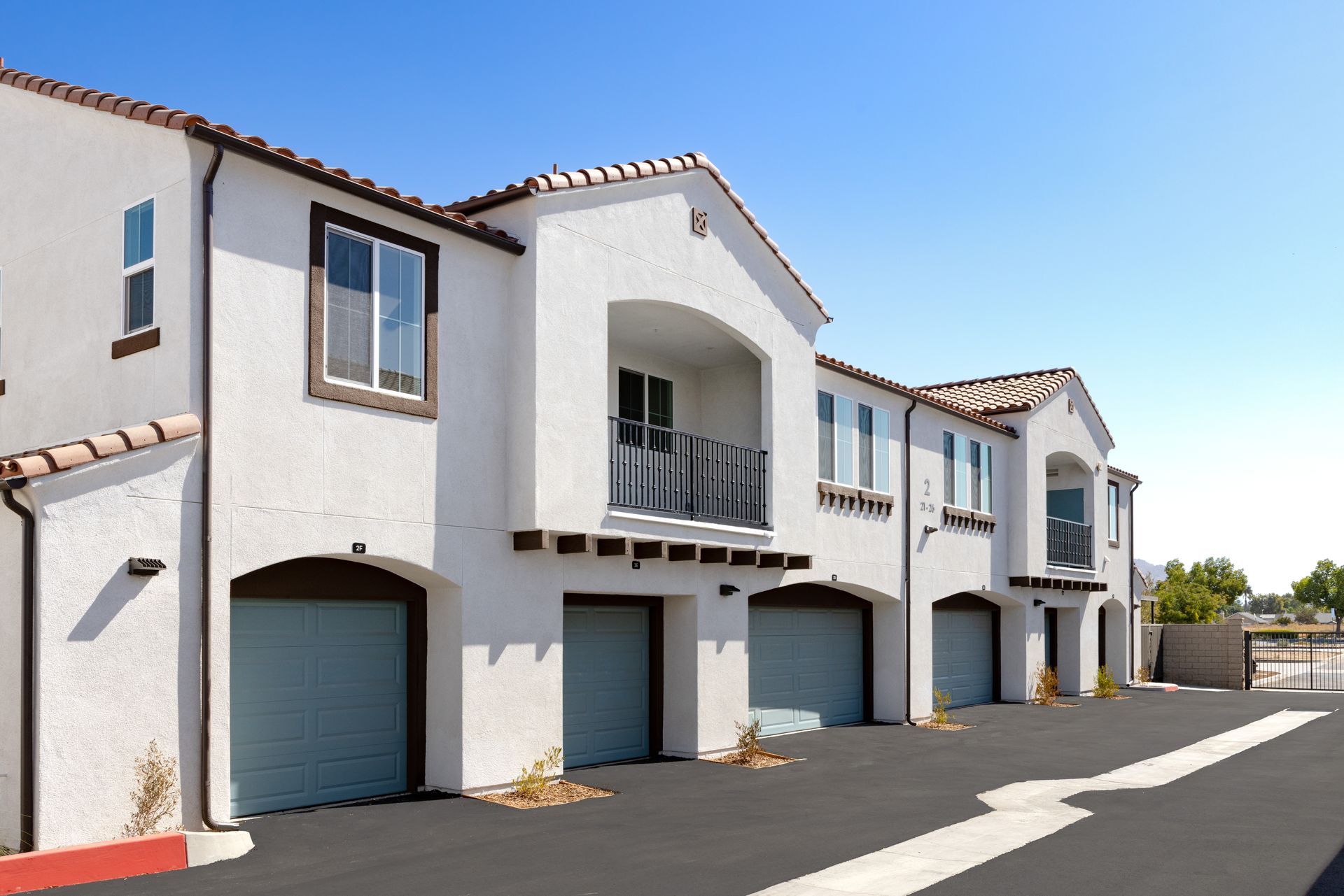 A white apartment building with a lot of garages