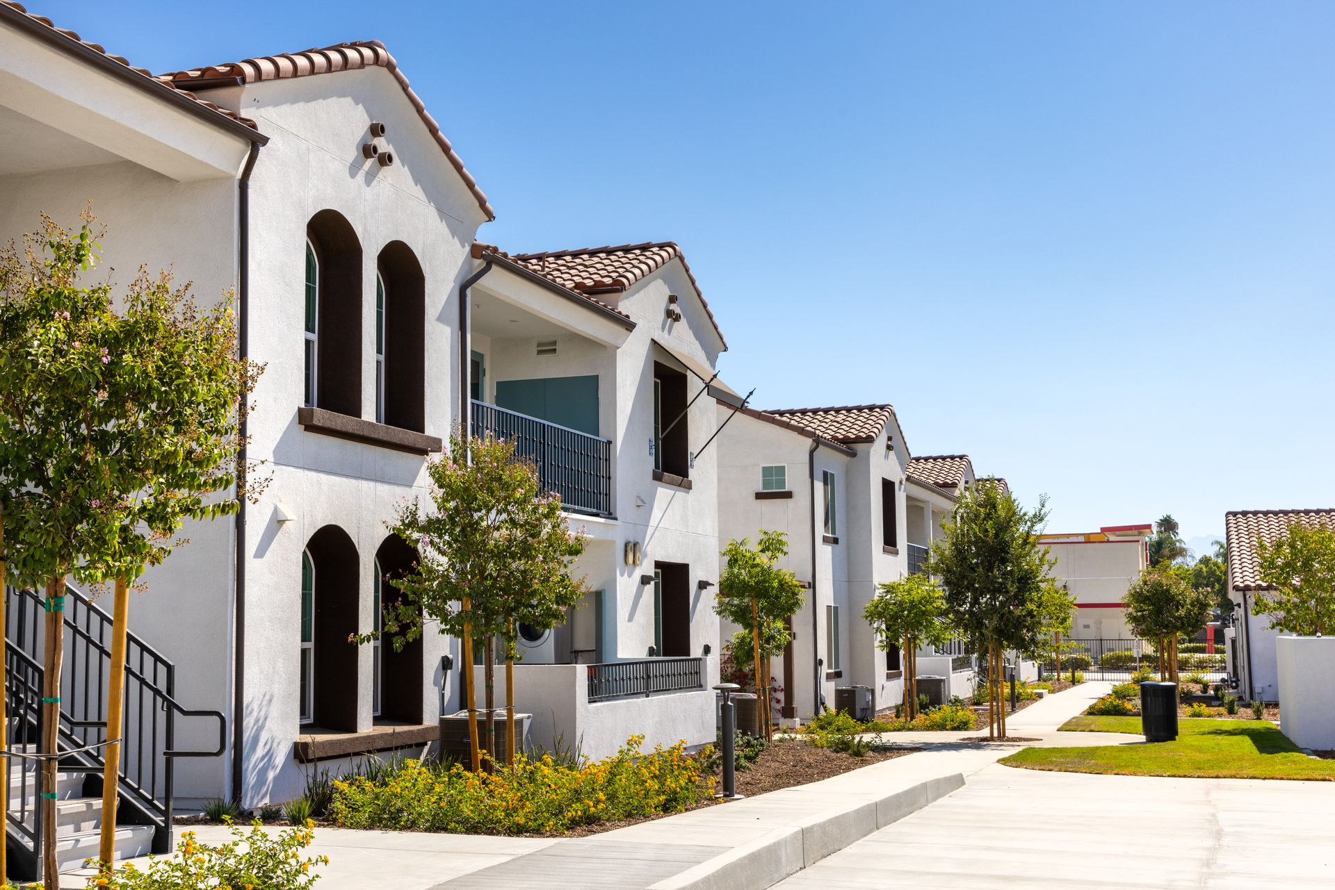 A row of white houses are lined up next to each other on a sunny day.