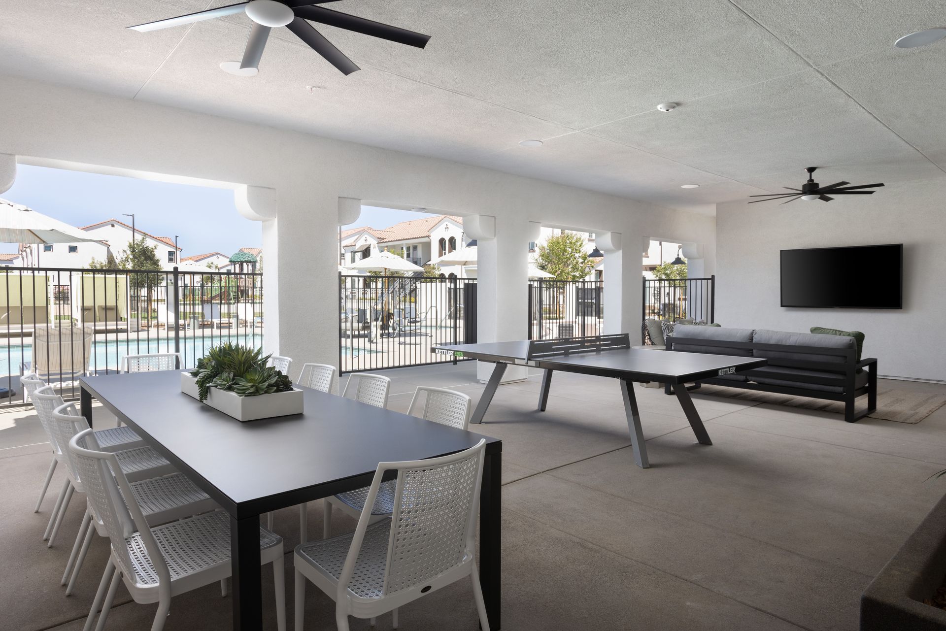 A large room with a table and chairs and a television