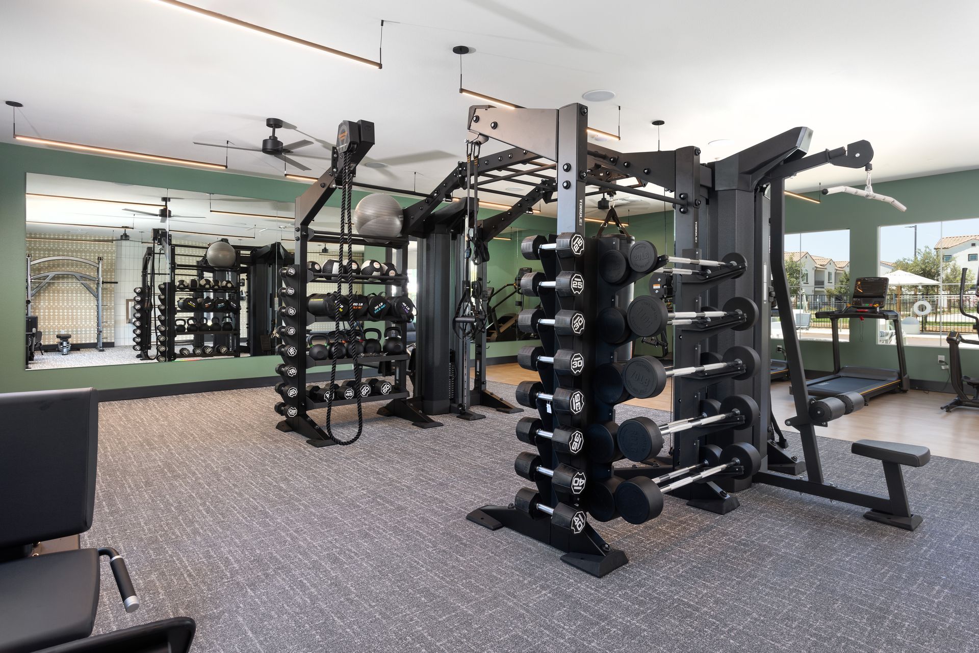 A large gym with a lot of dumbbells and exercise equipment