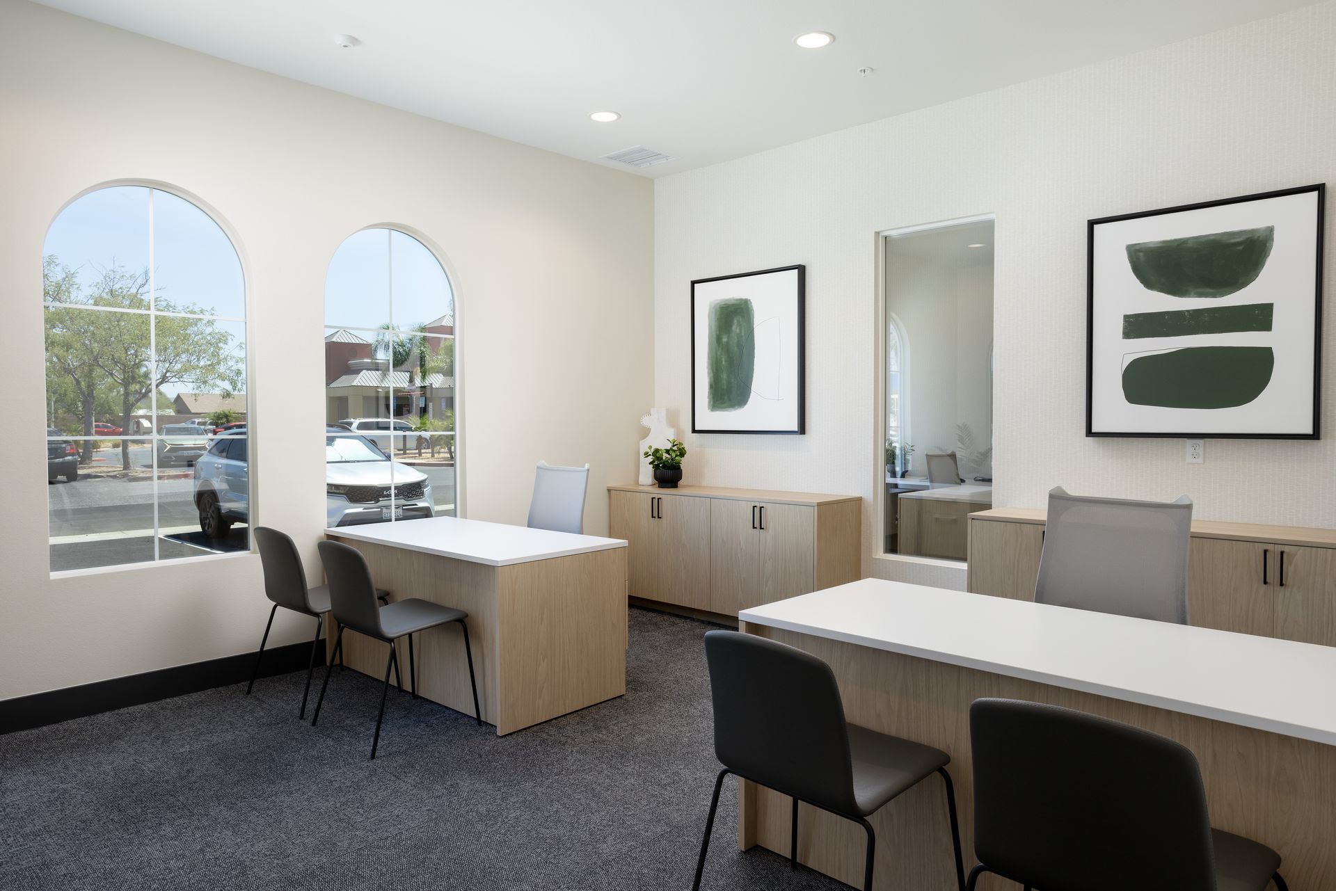 A room with a lot of windows and tables and chairs.