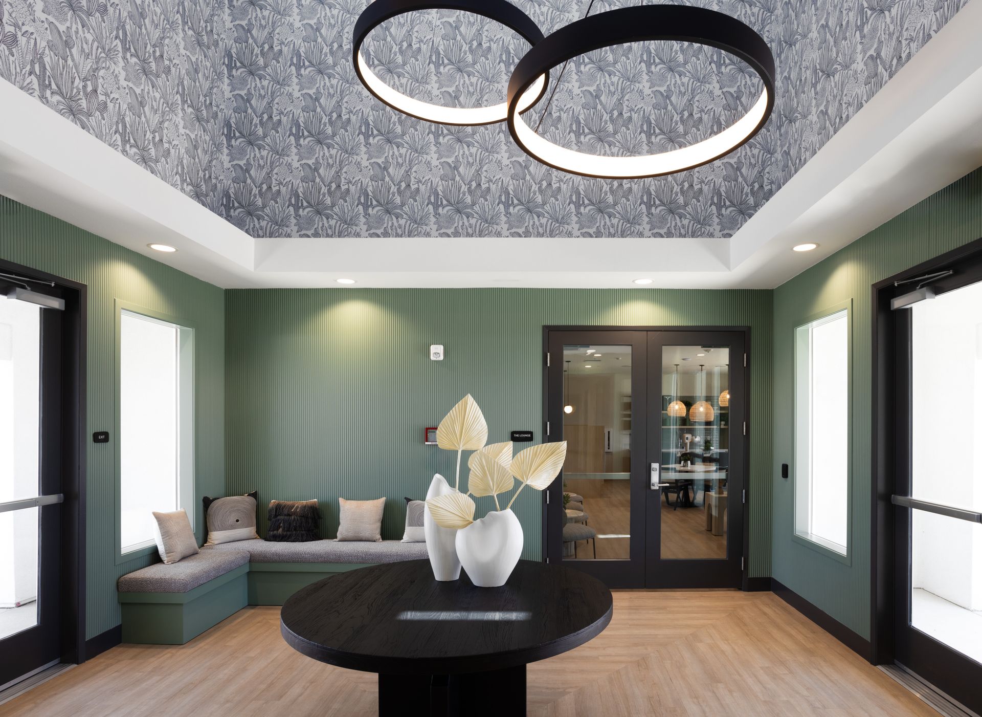 A living room with a round table and a vase of flowers on it