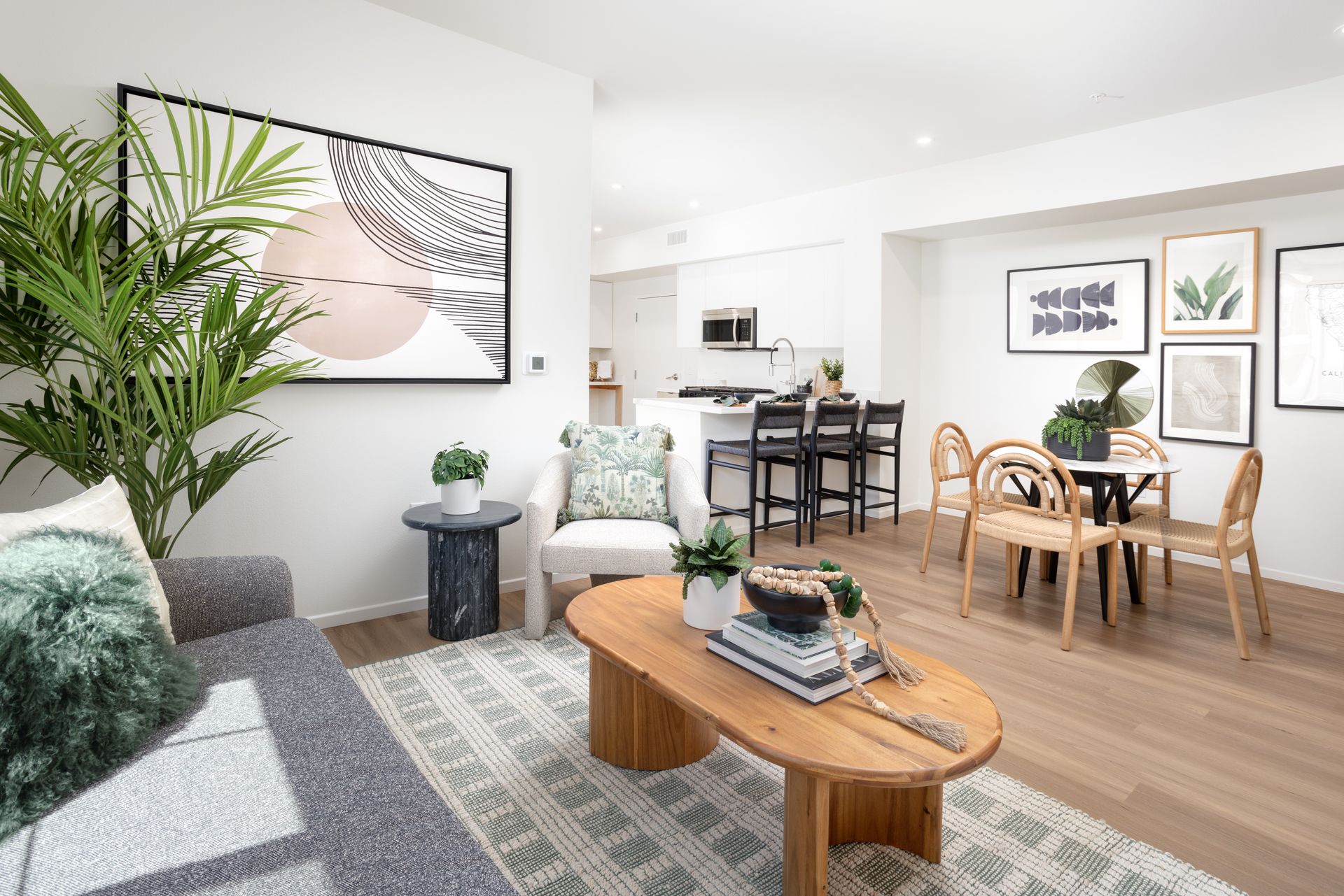 A living room with a couch , chair , coffee table and dining table.