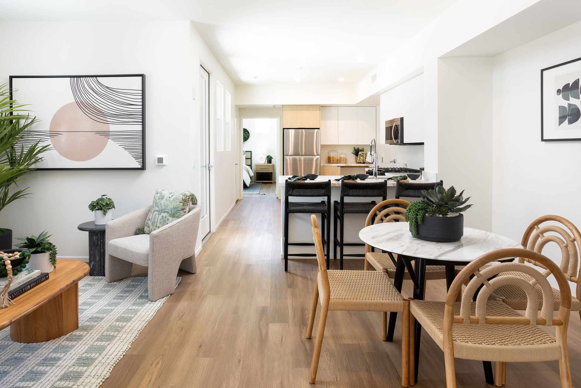 A living room and dining room in a house with a table and chairs.