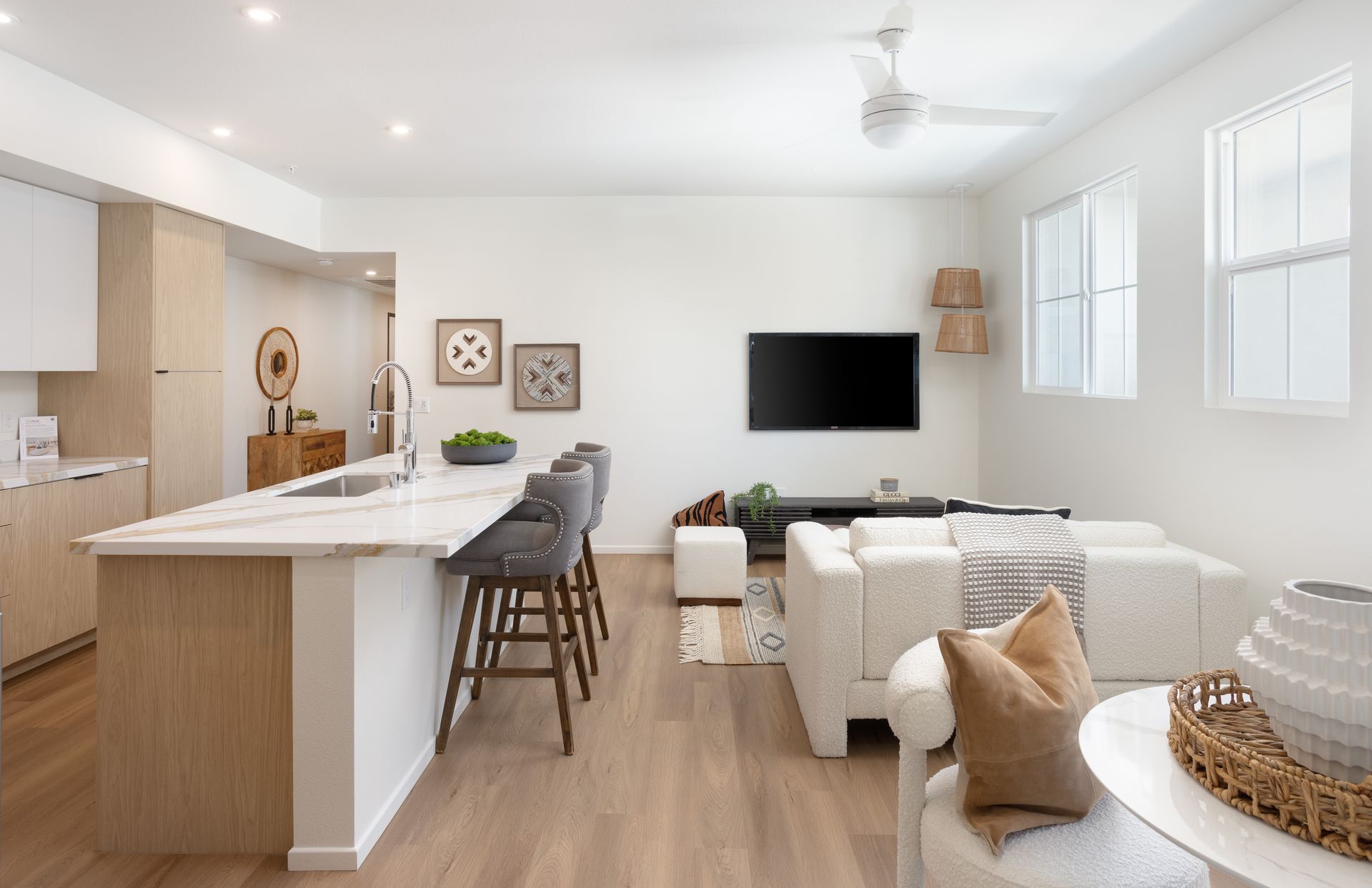 A living room with a couch , chairs , and a flat screen tv.