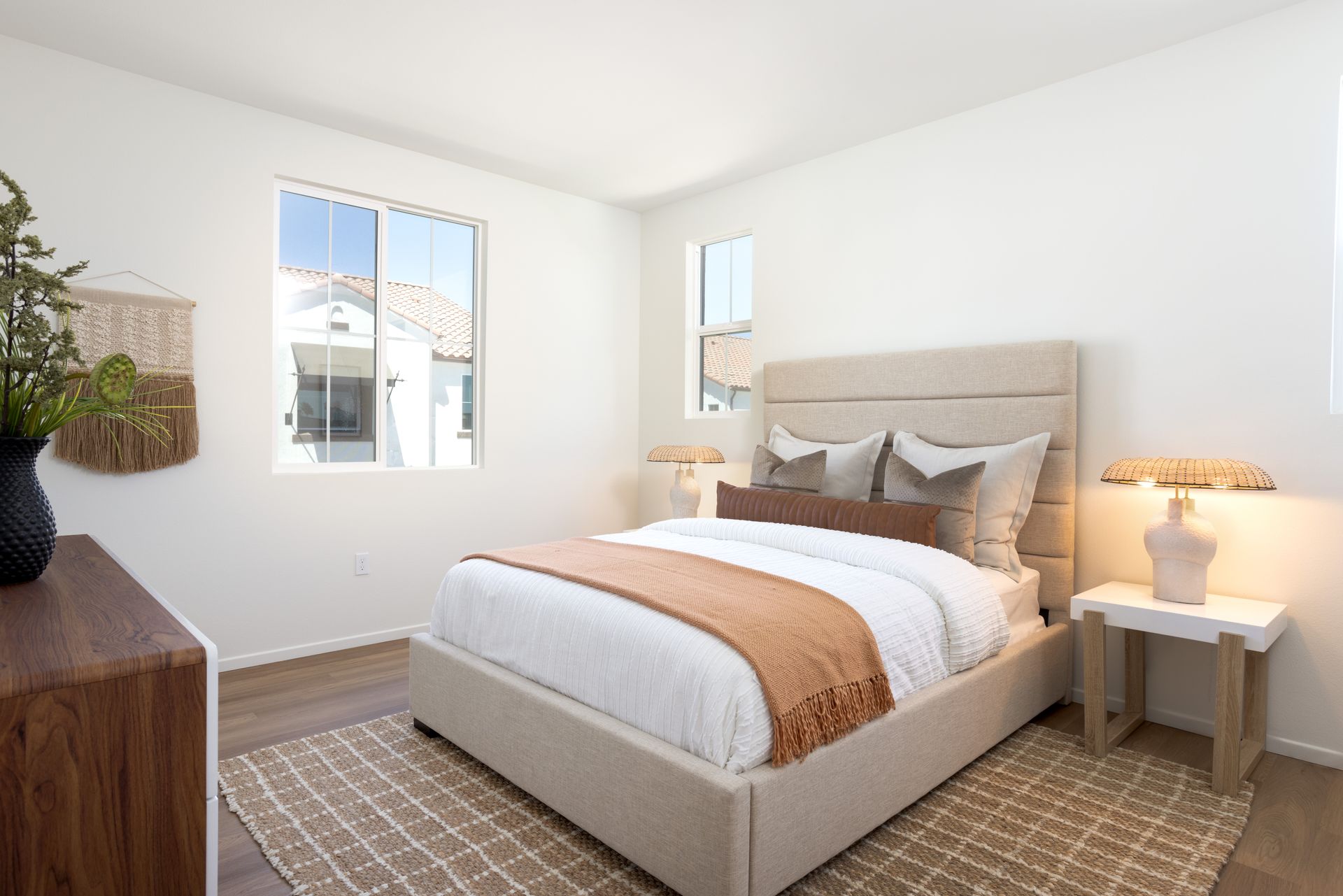 A bedroom with a bed , dresser , nightstand and window.