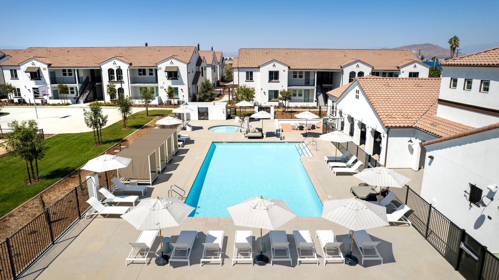 An aerial view of a large swimming pool surrounded by chairs and umbrellas