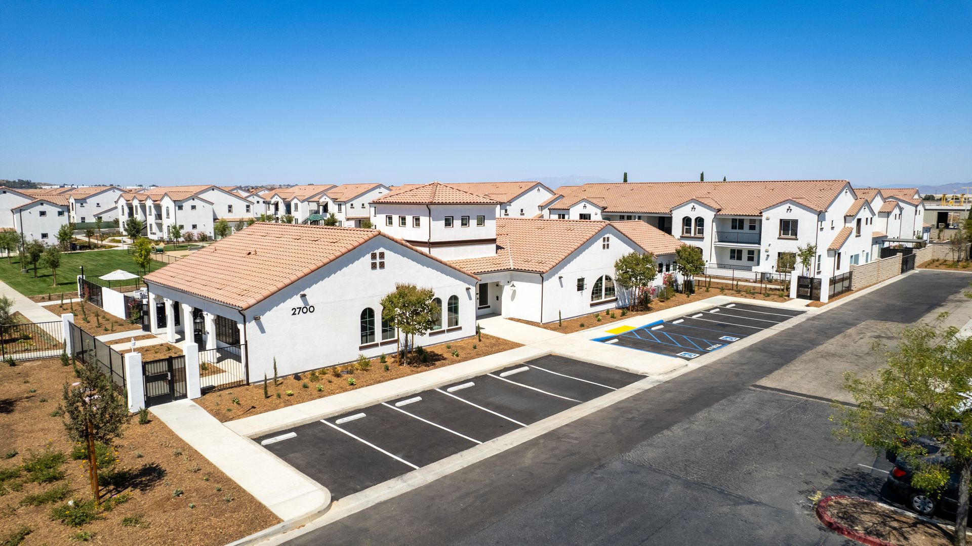 An aerial view of a residential area with lots of houses and a parking lot.