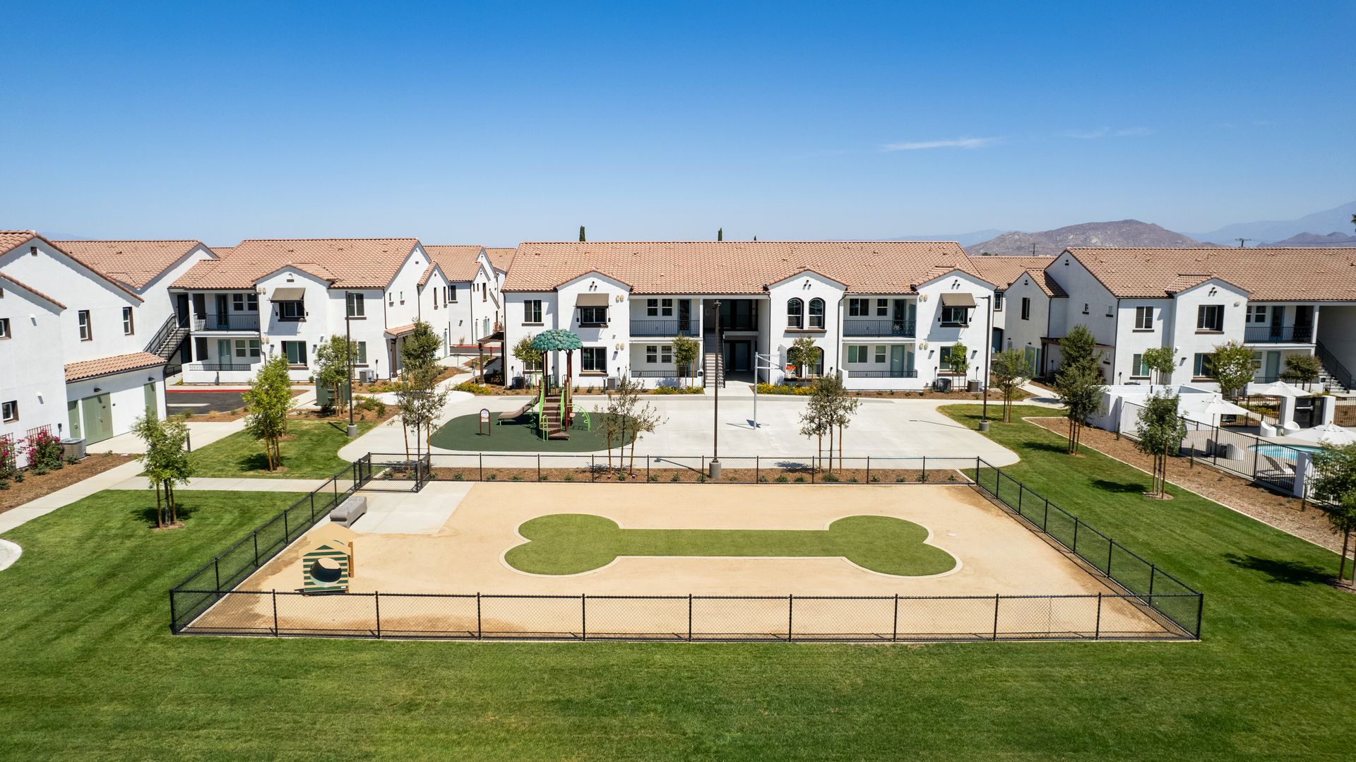 An aerial view of a dog park in front of a row of houses.