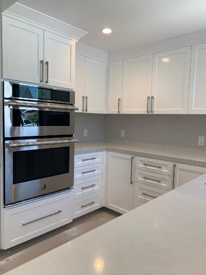 A kitchen with white cabinets and stainless steel appliances.