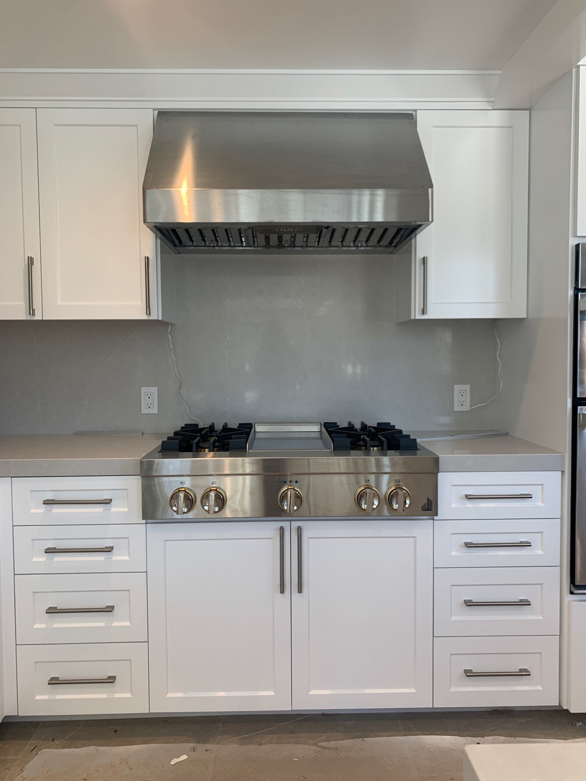 A kitchen with stainless steel appliances and white cabinets