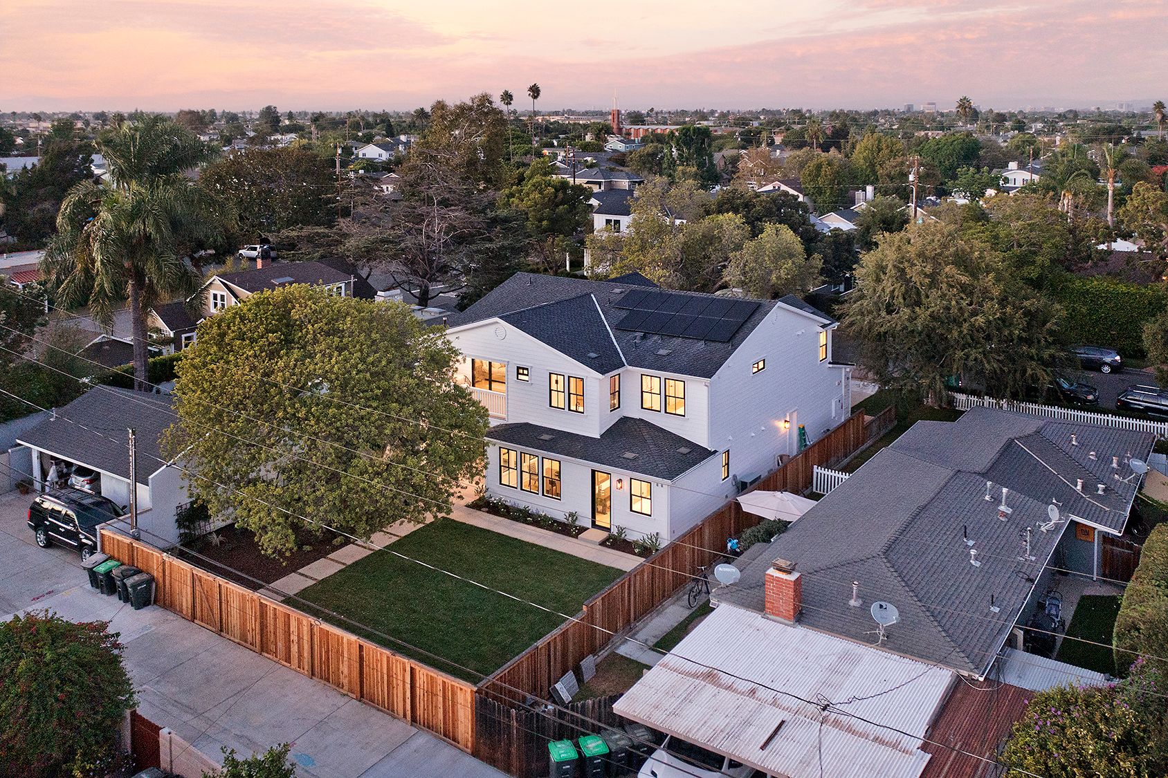 An aerial view of a residential neighborhood with a large white house in the middle.