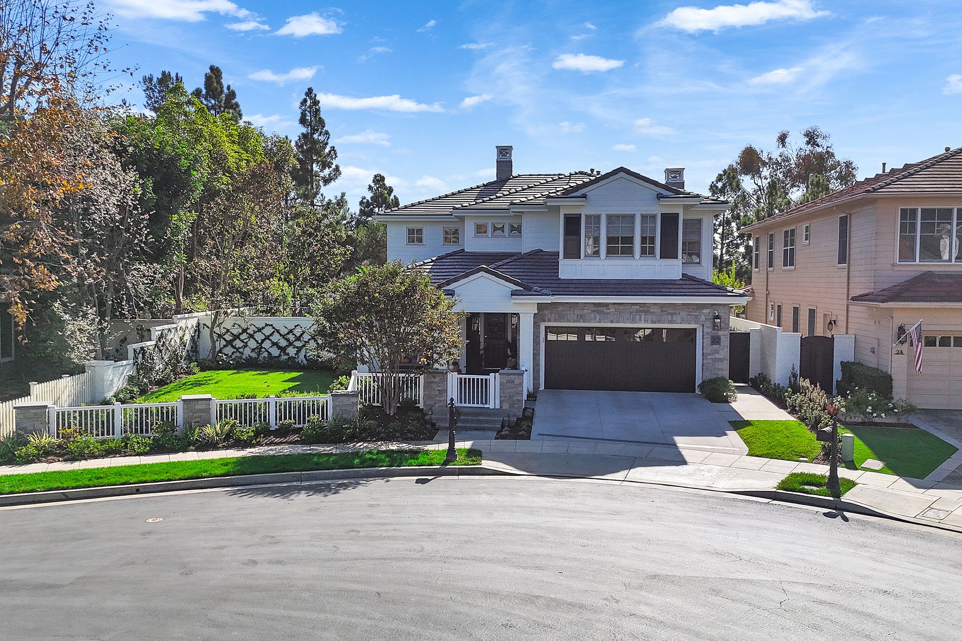 Two-story house with gray roof, driveway, and lawn; set on a suburban street.